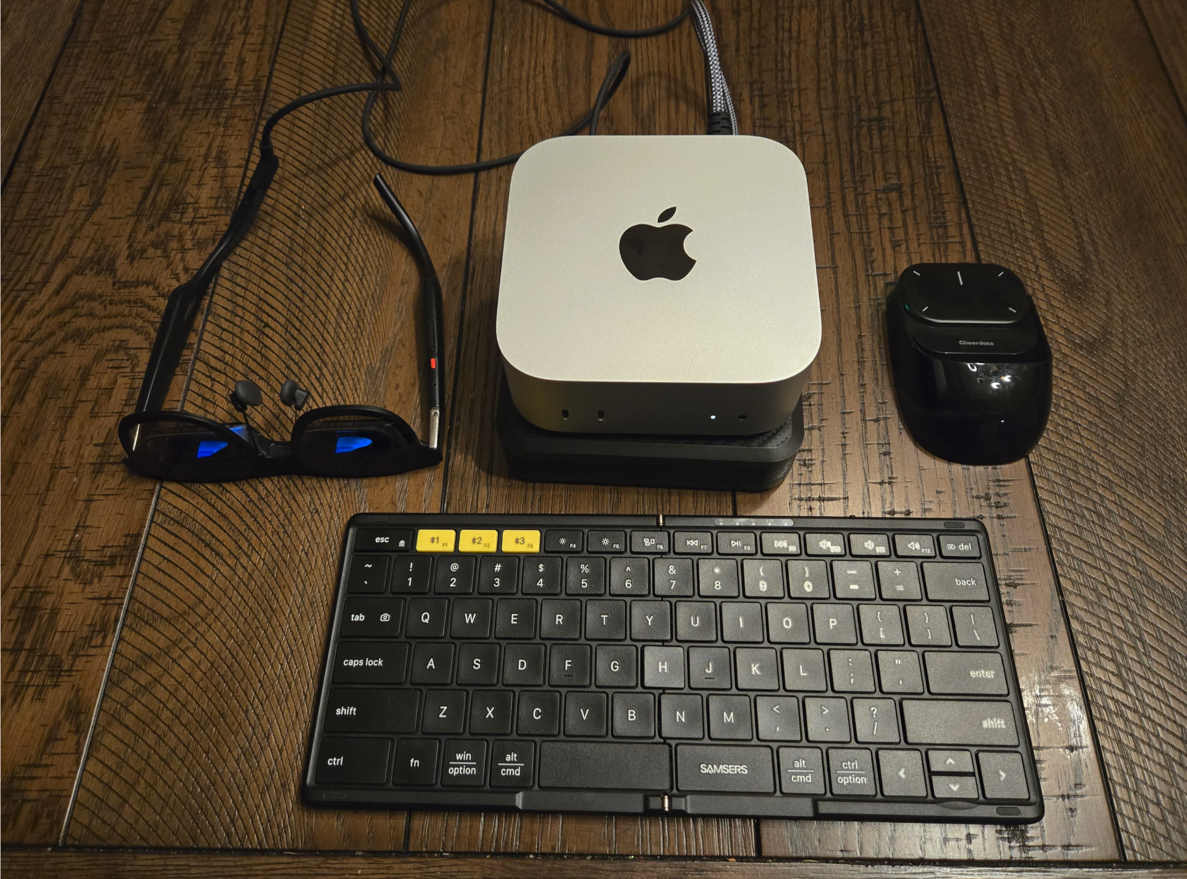 A mini Apple computer, wireless mouse, compact keyboard, and a pair of black wireless earbuds with charging case are placed on a wooden surface.
u/harrybootoo's Portable Mac Mini + Xreal One Pro