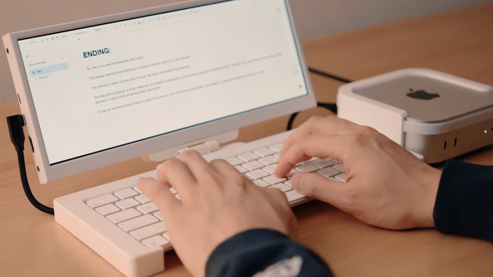 A person is typing on a white keyboard connected to a small device with a screen displaying text titled ENDING.
Scott Yu-Jan's Portable M4 Mac mini