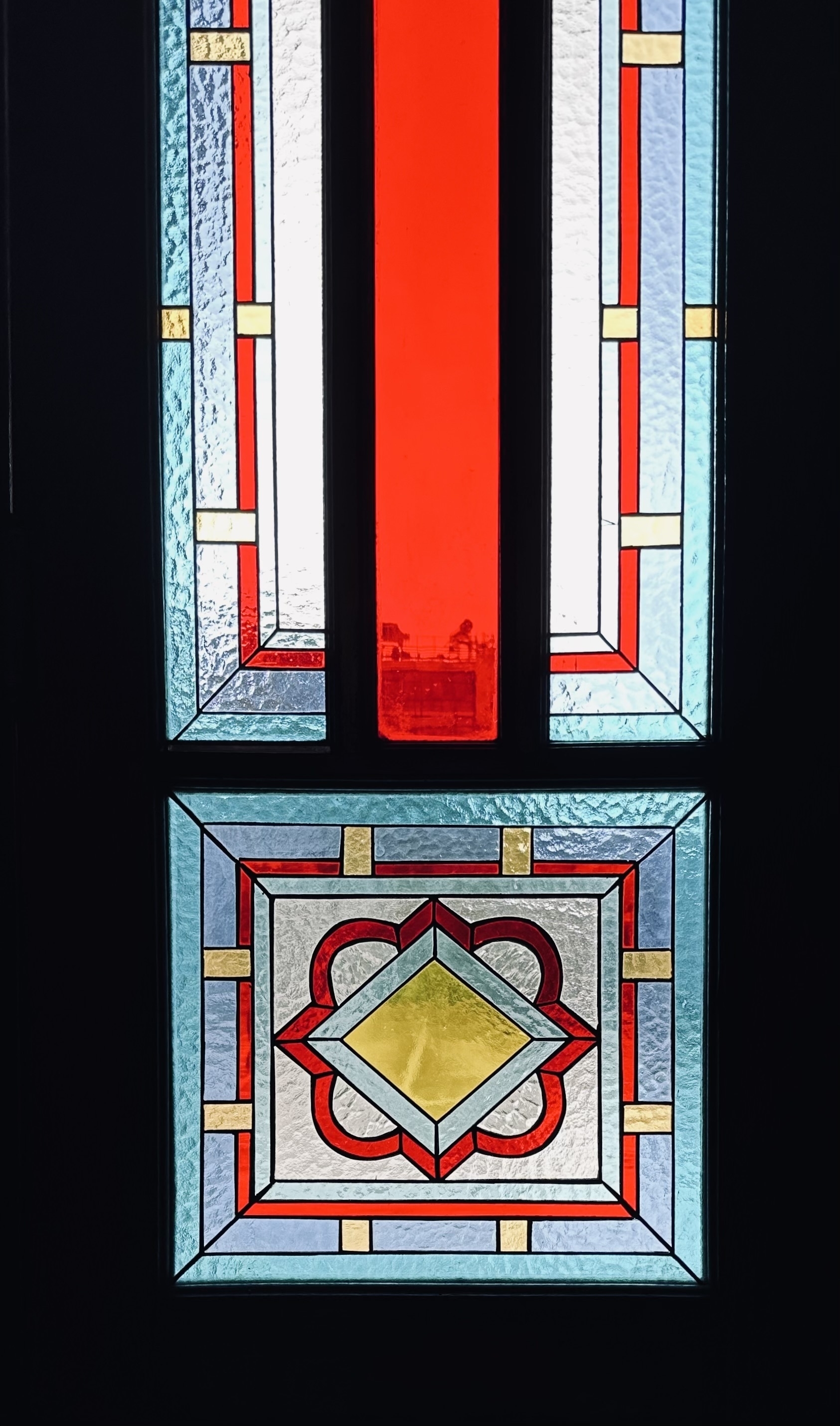 Red, blue and yellow stained glass in a door.