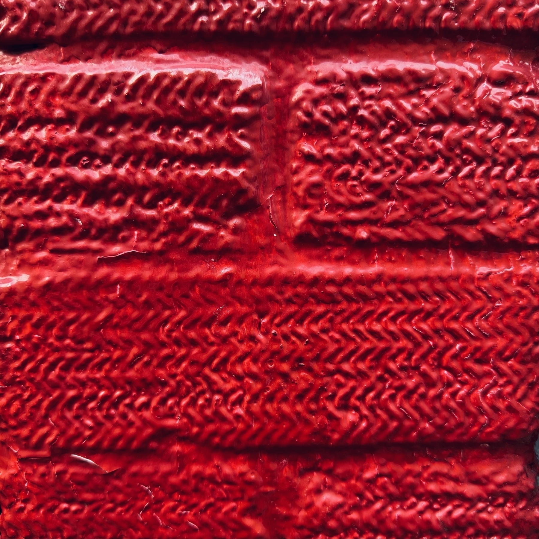 Close up of a brick wall, painted bright red.