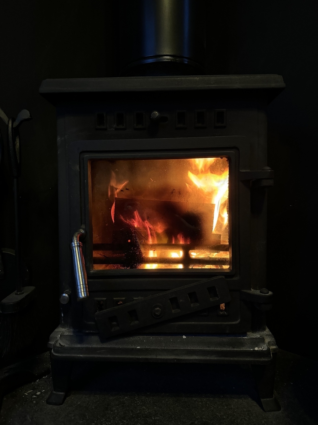 A wood burning stove with a fire inside.
