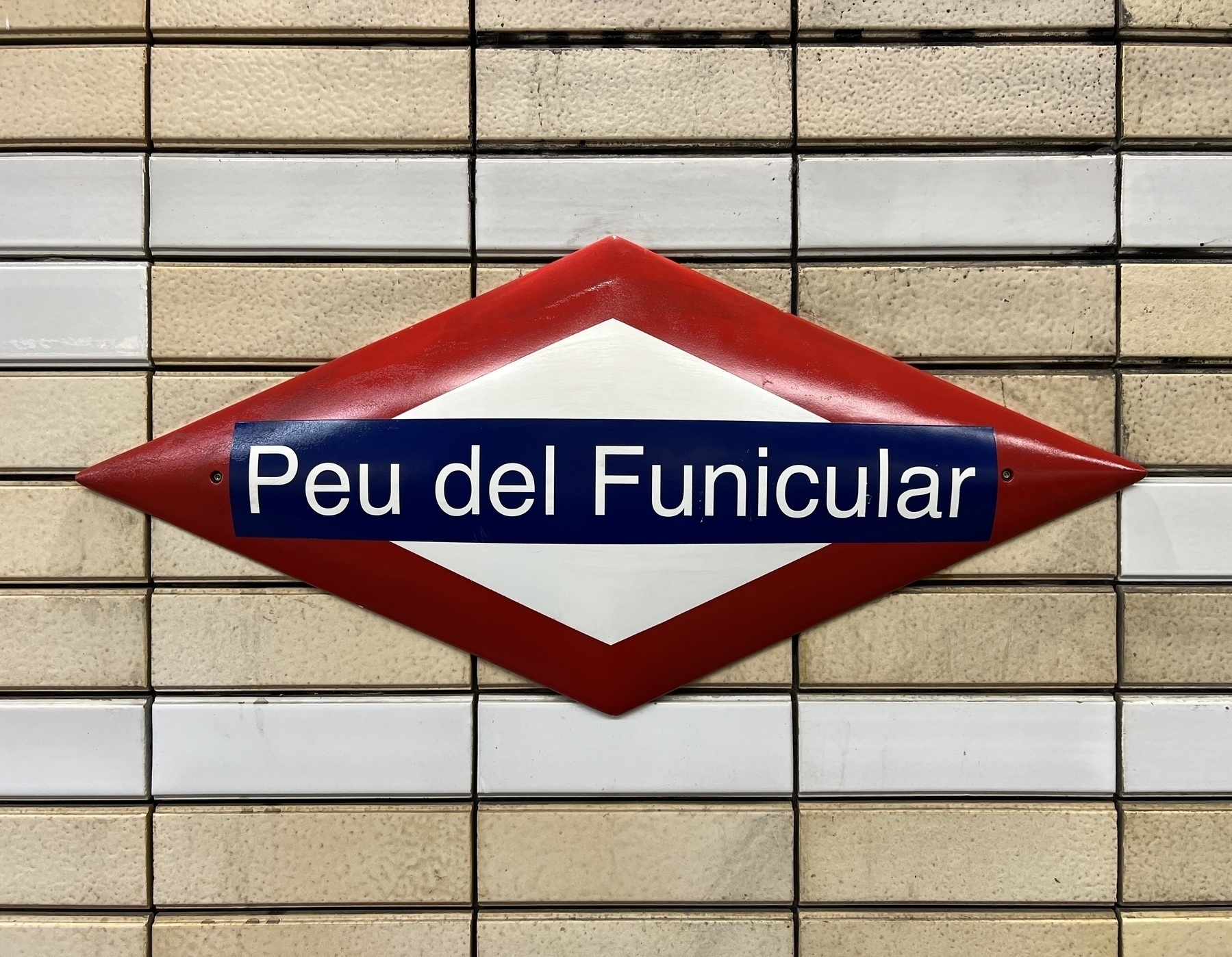 A sign in a red diamond that says “Peu del Funicular”