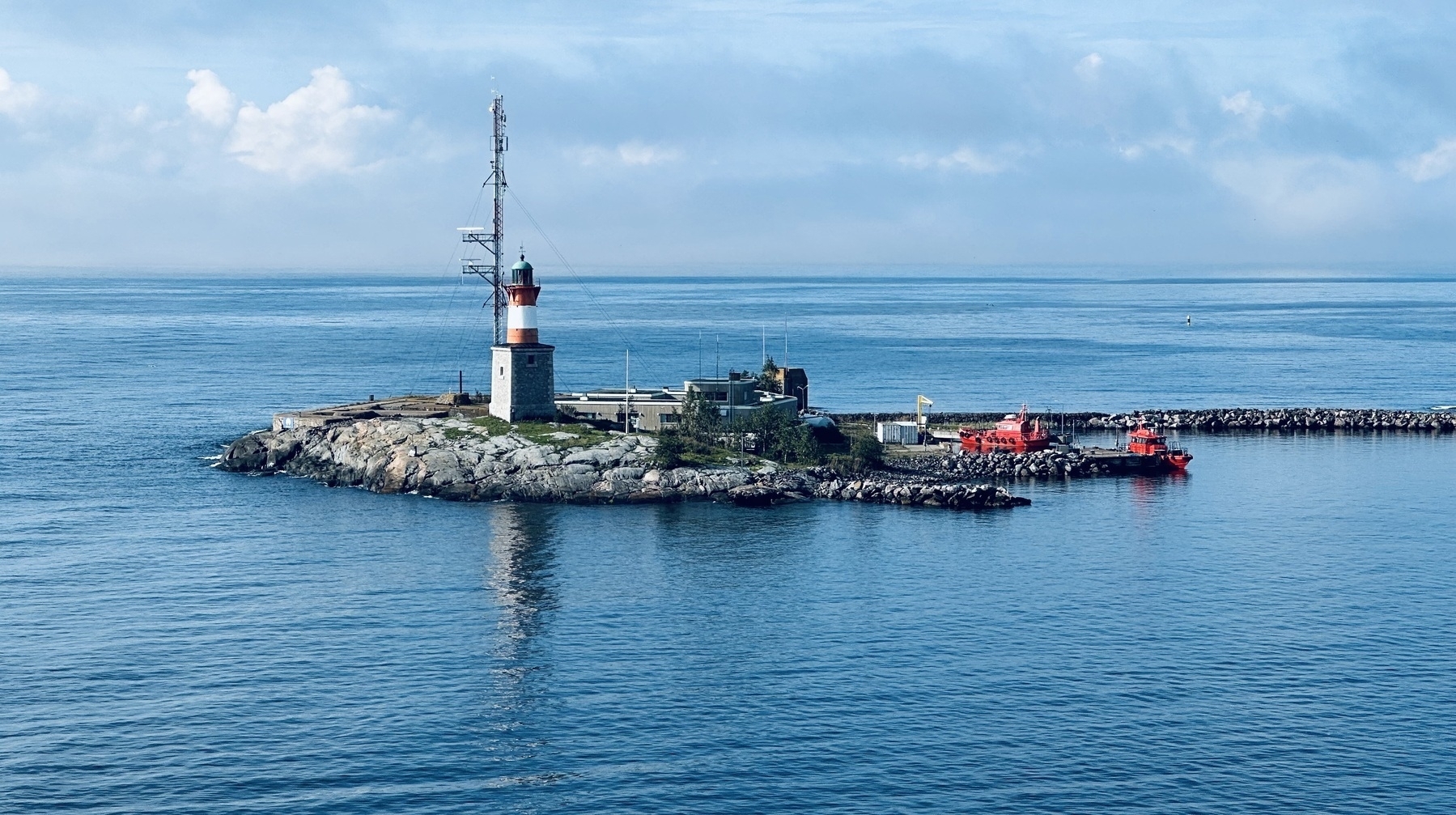 A small lighthouse and harbour on a rocky island.
