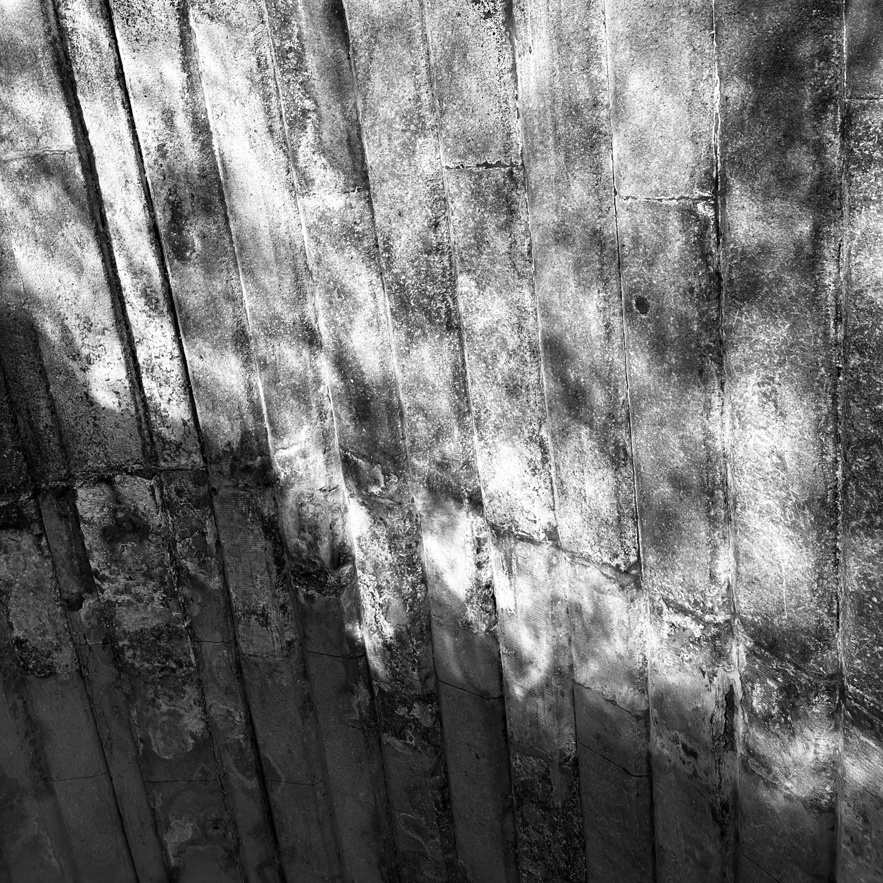Caustics on the underside of a brick arched bridge, from sunlight reflecting off the river the bridge crosses.