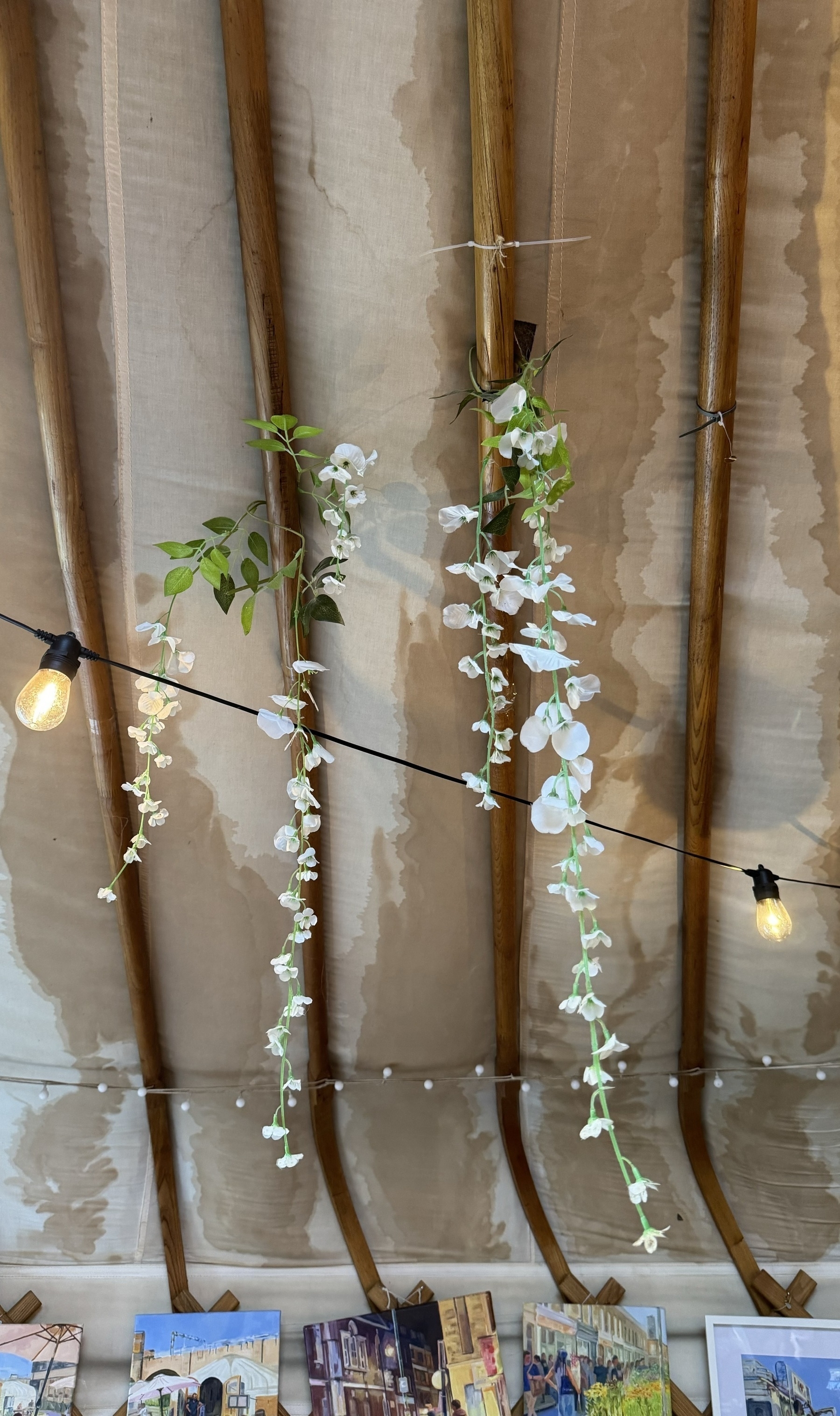 Fake flowers hanging from the roof of a yurt.