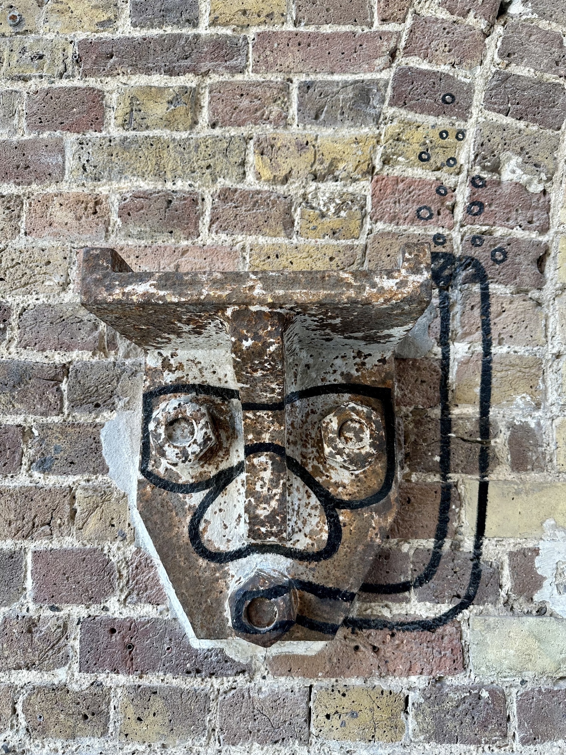 The end of a metal girder sticking out from a brick wall. A snorkel, goggles and bubbles have been drawn on to the girder and wall to make it look like someone snorkelling.