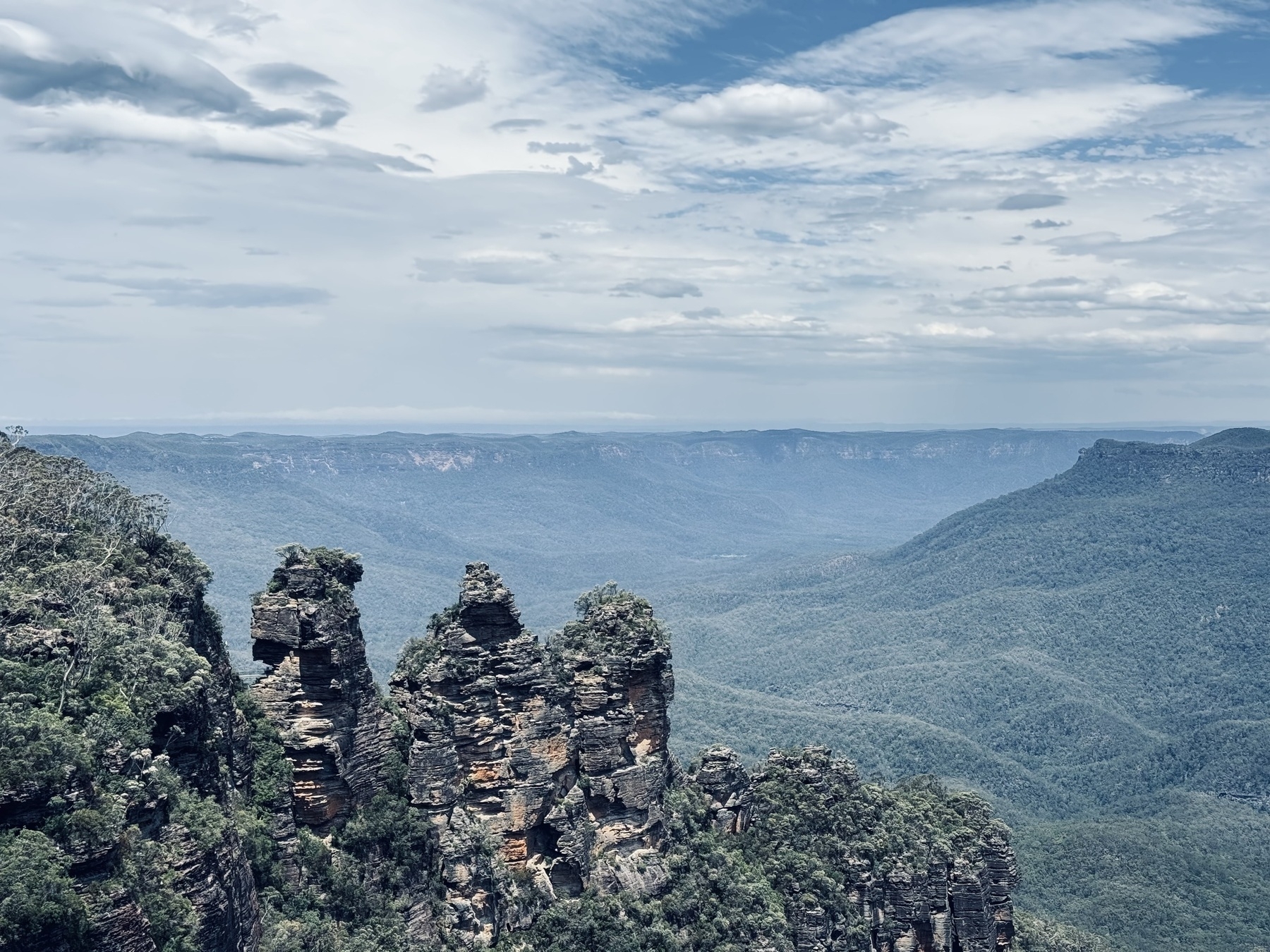 Rock formations in the foreground with valleys of the Blue Mountains in the background.