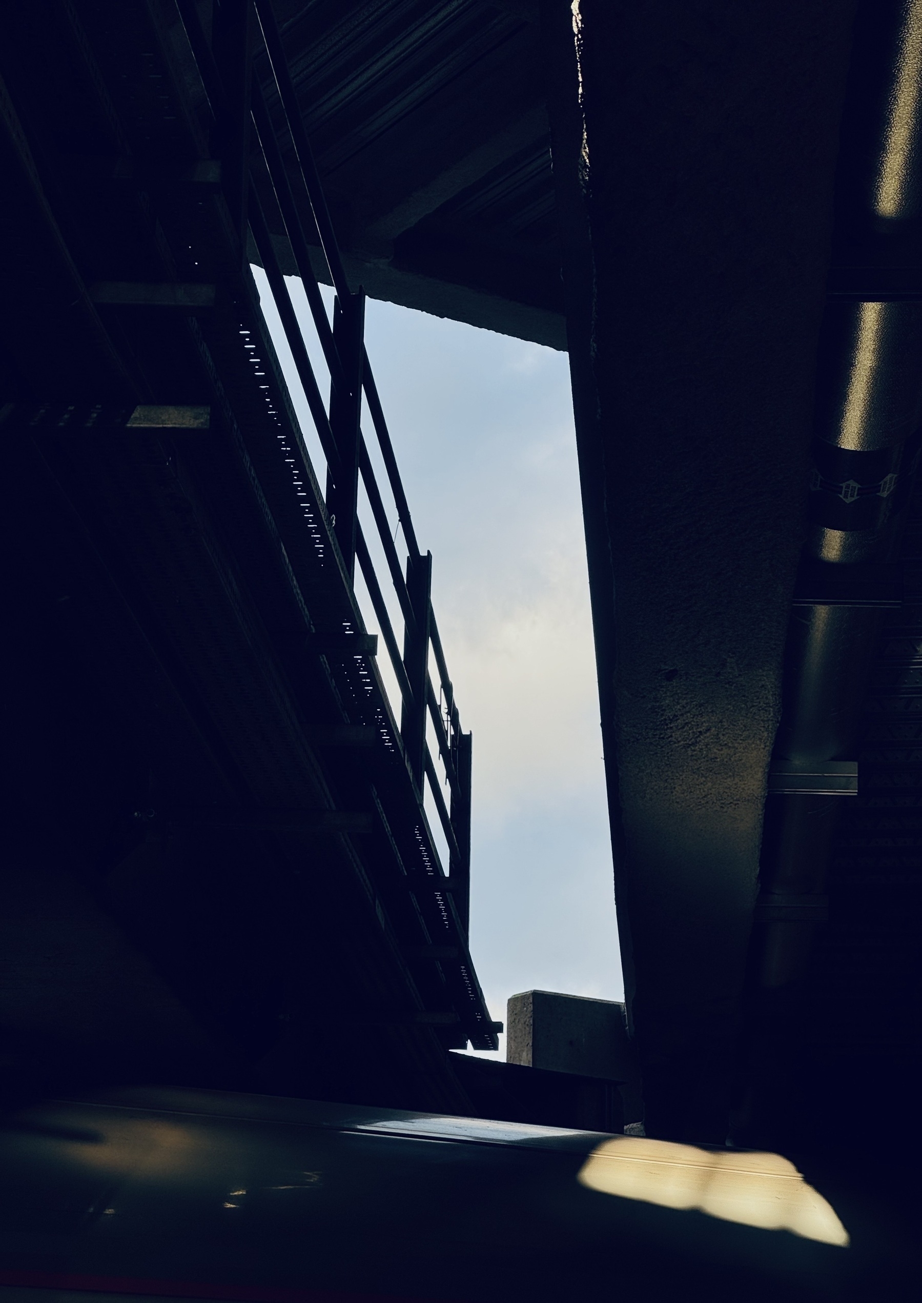A sliver of sky seen through the side of a train station.