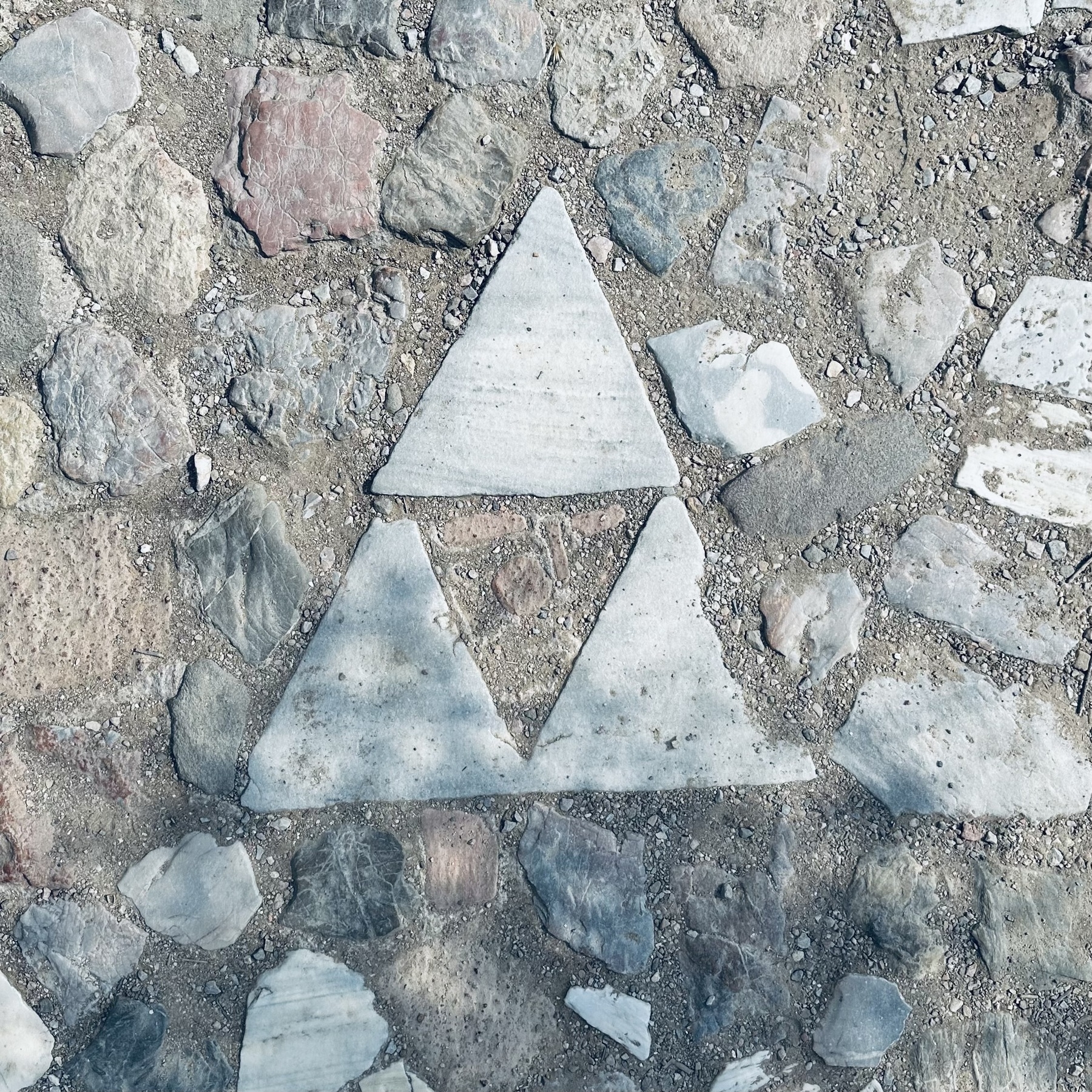 Three stone triangles embedded in the ground.