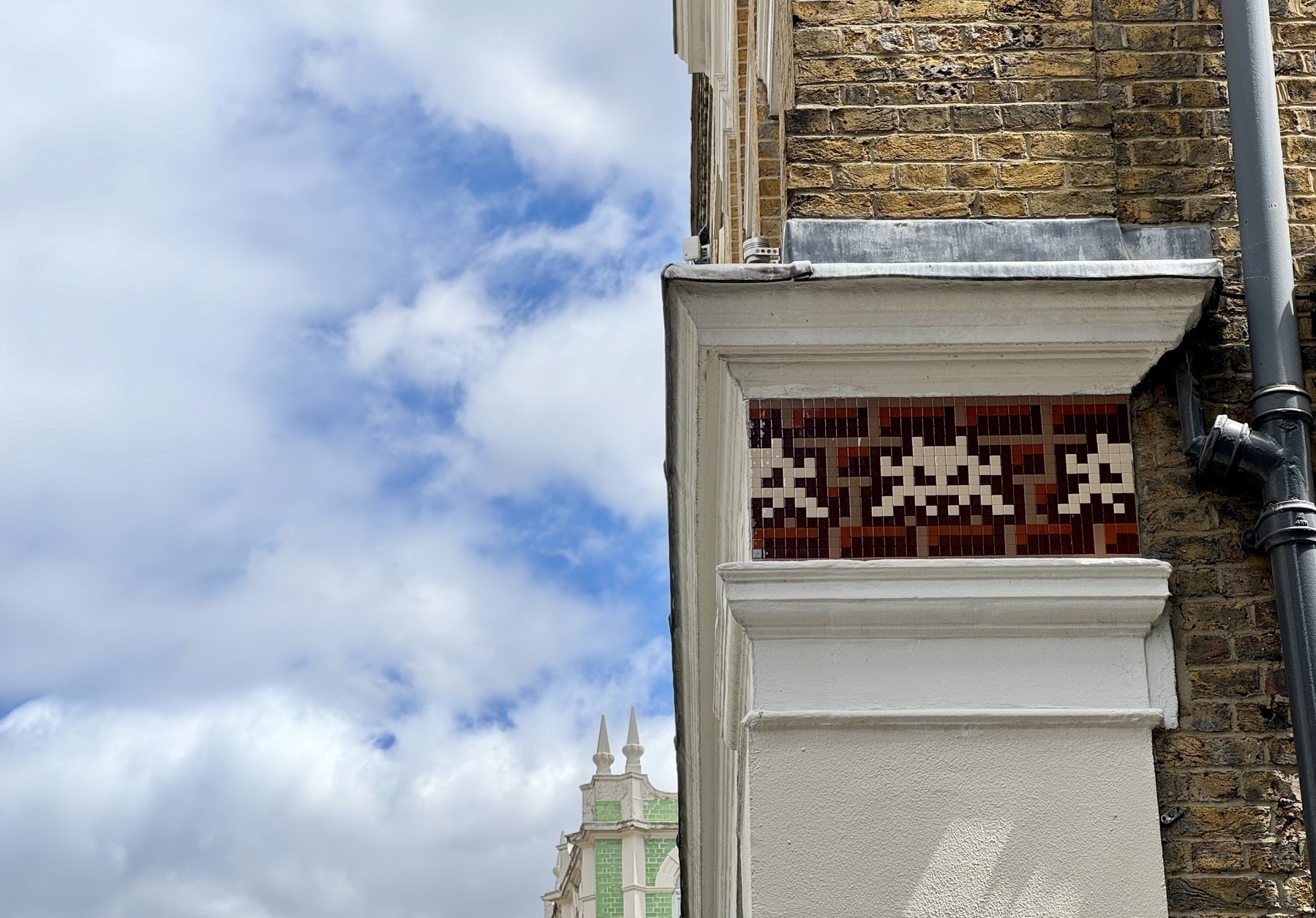 Tiled space invaders hiding on a wall.