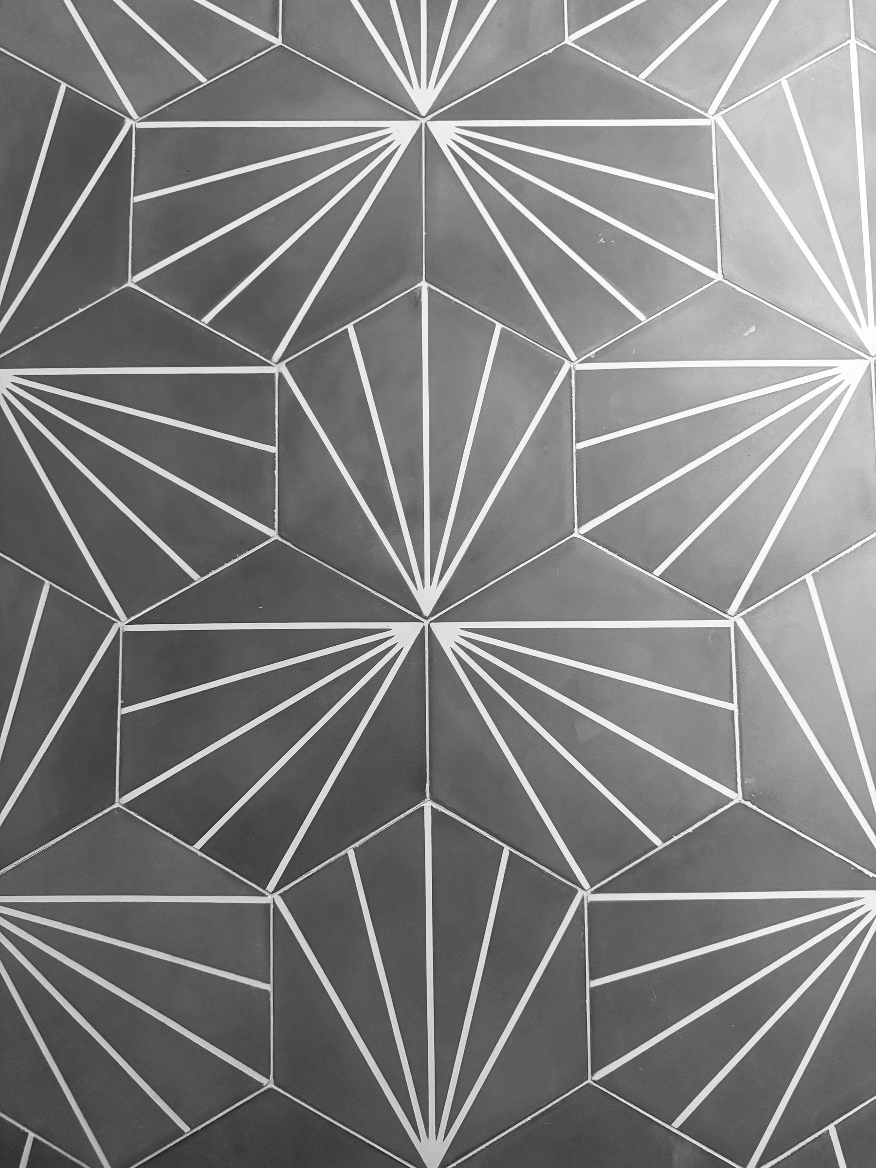 Grey hexagonal tiles with a pattern of white lines on them.
