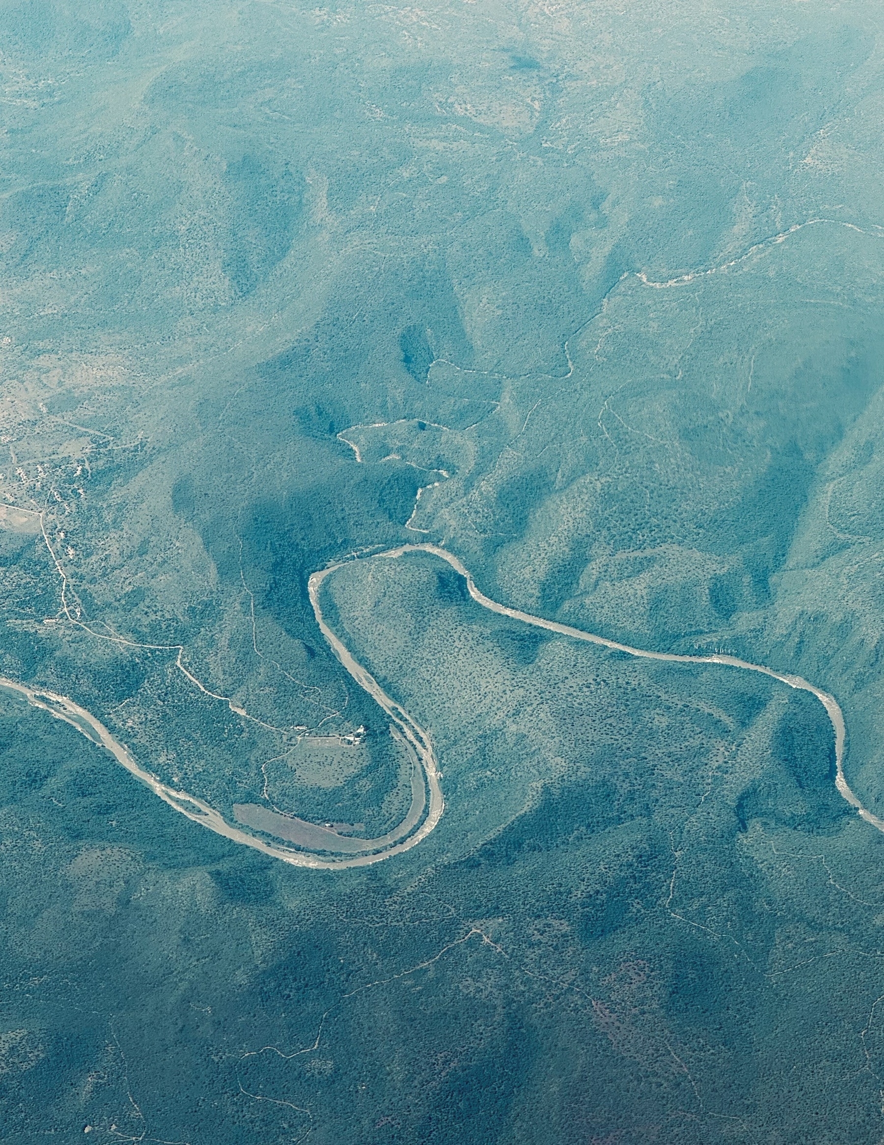 A river winding through hills, seen from the air.