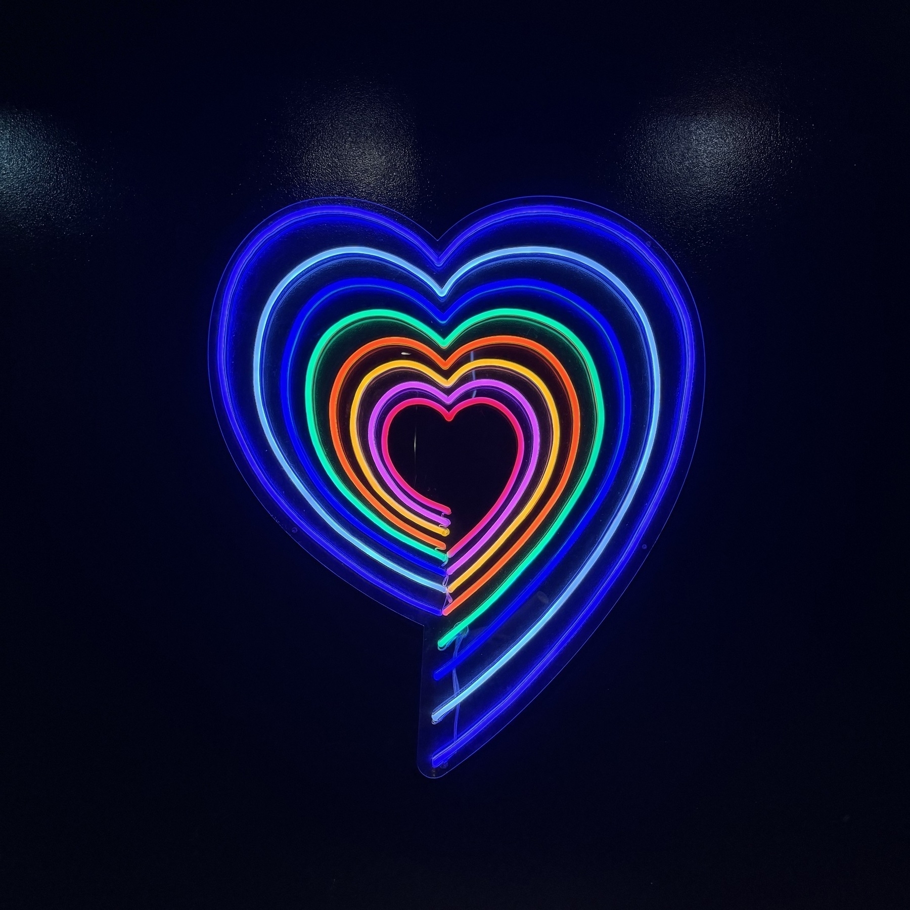 Concentric neon hearts in different colours.