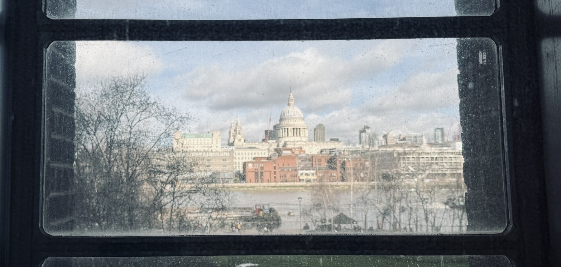 St Paul’s cathedral and the river Thames seen through a dirty window.