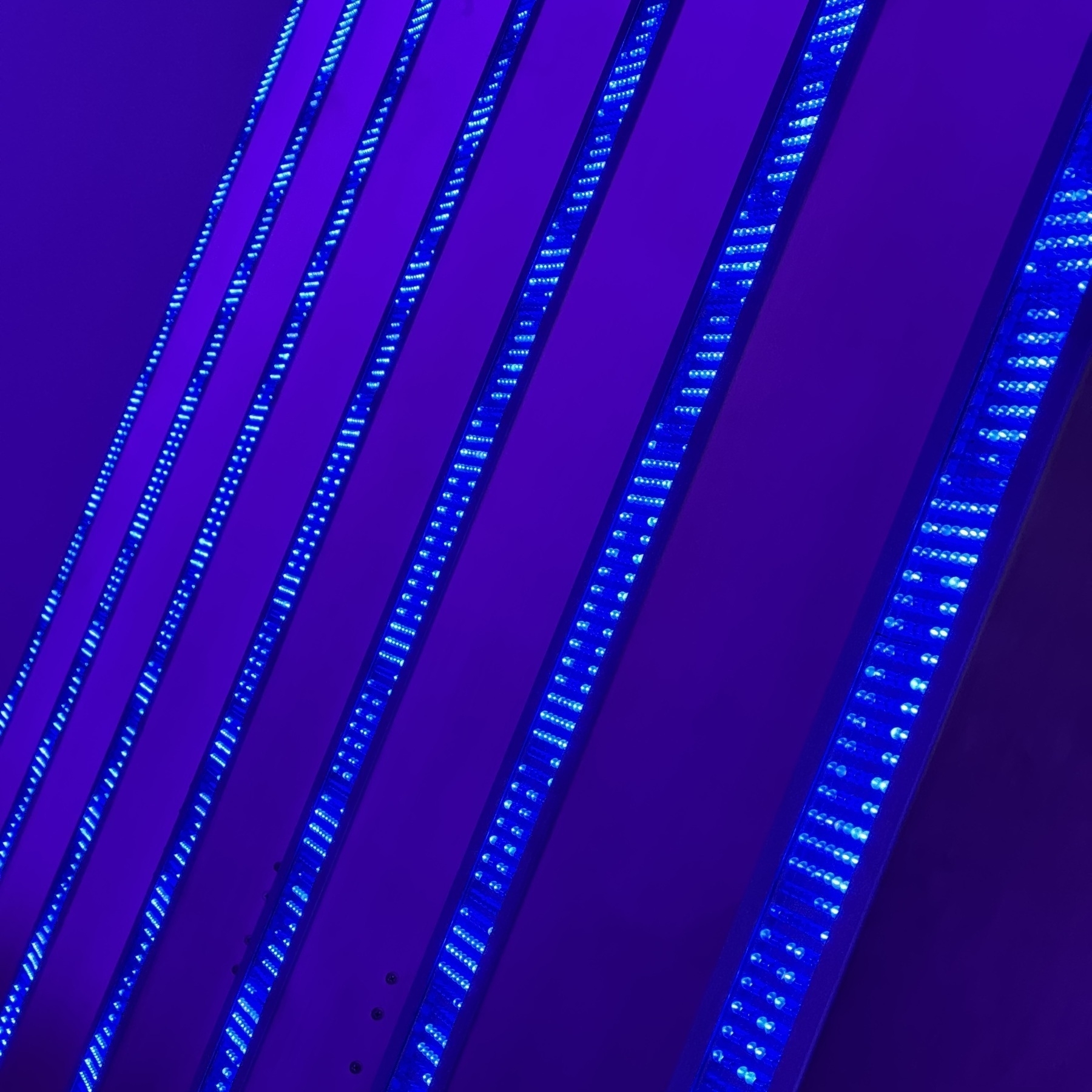 Blue LEDs scrolling down a series of diagonal beams, side lit by purple light.