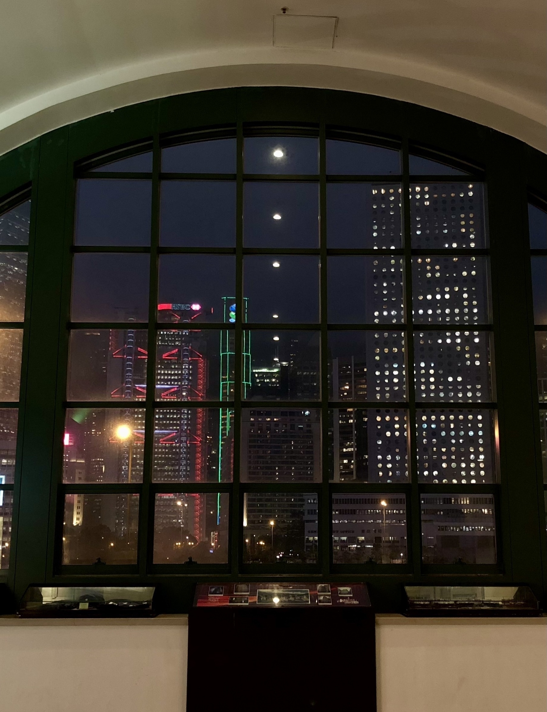 The skyline of Hong Kong seen through a window at night.
