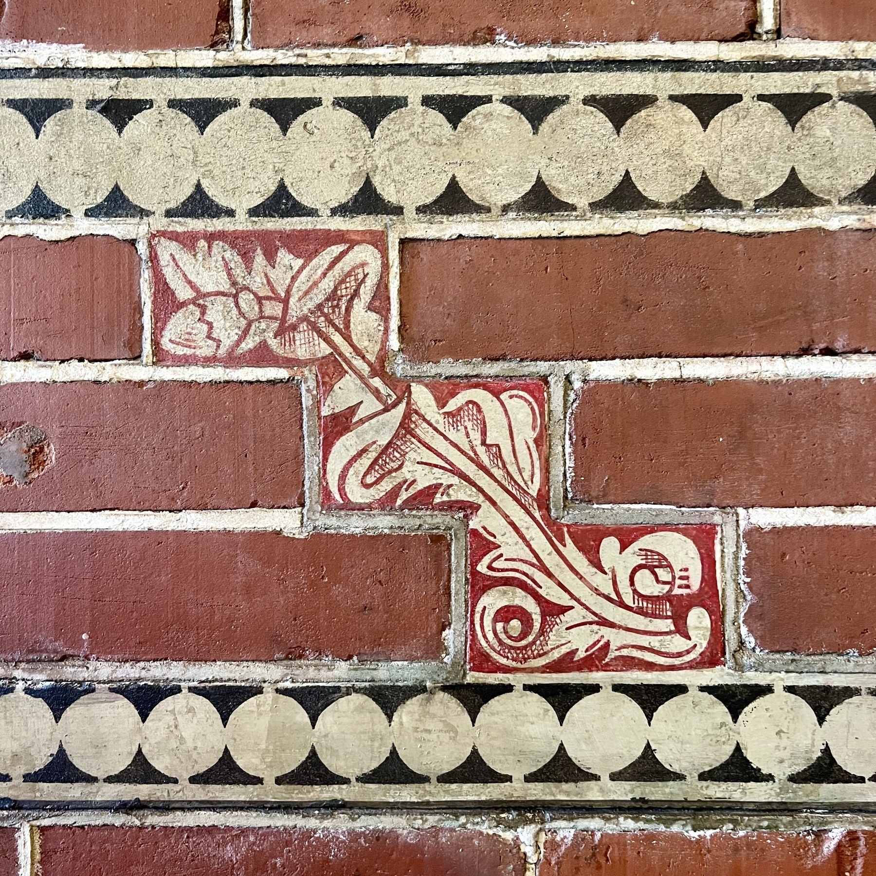 A leafy tile amongst bricks.