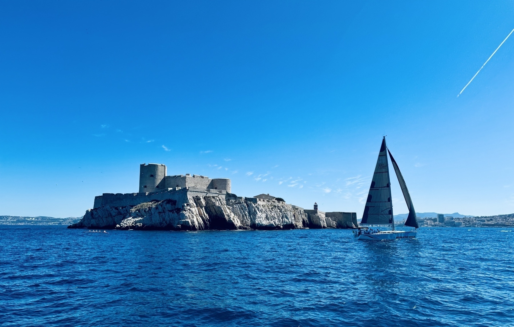 A boat sailing past chateaux d’If off the coast of Marseille.