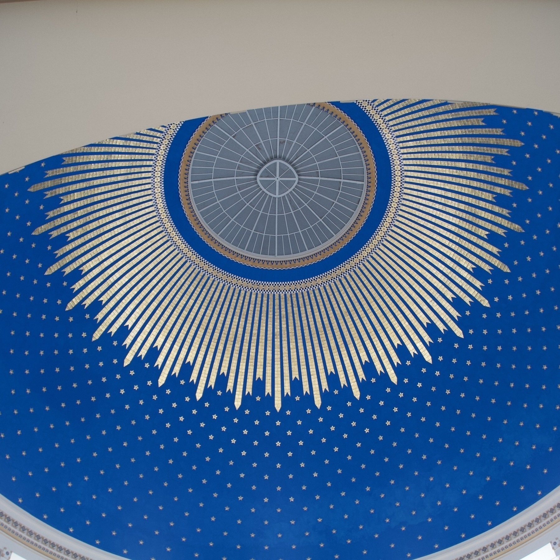 The ceiling of a dome painted in blue and gold.