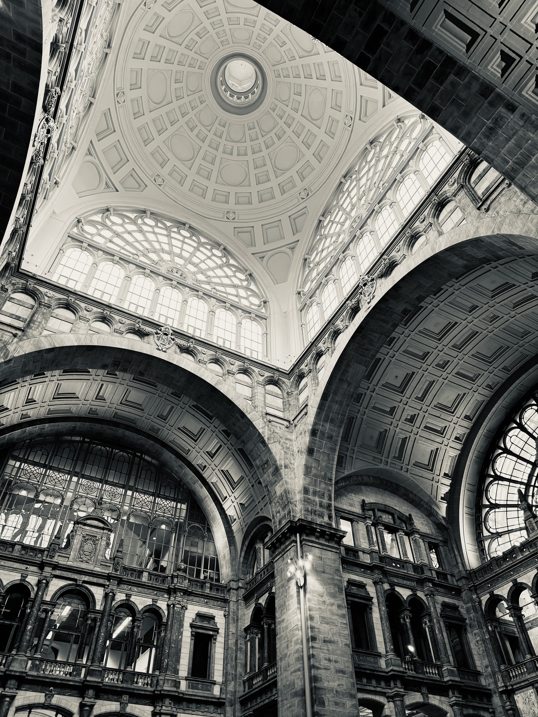 Arches holding up the main dome of Antwerp train station, in black and white.