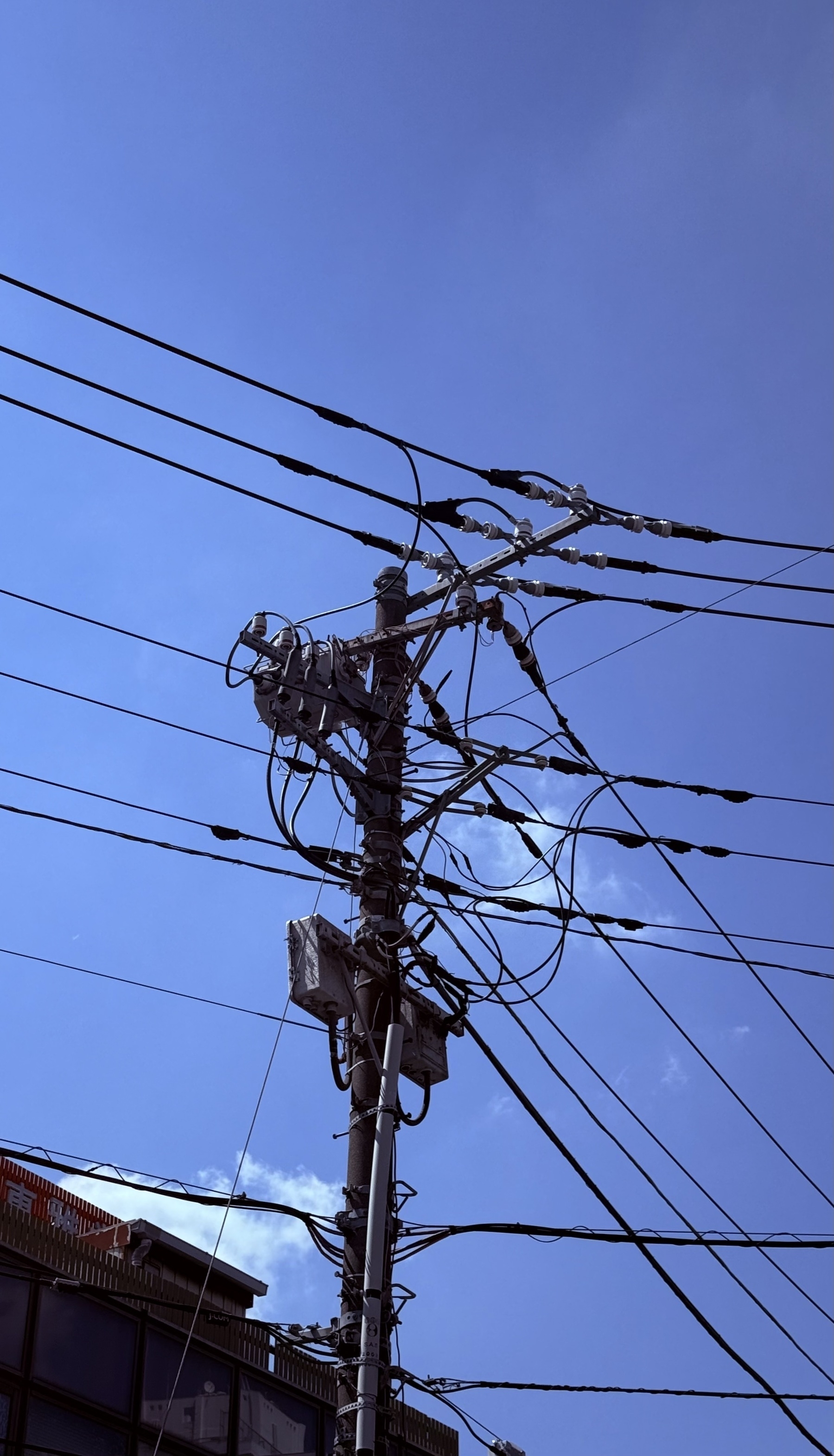 A pole holding up a tangle of power cables.