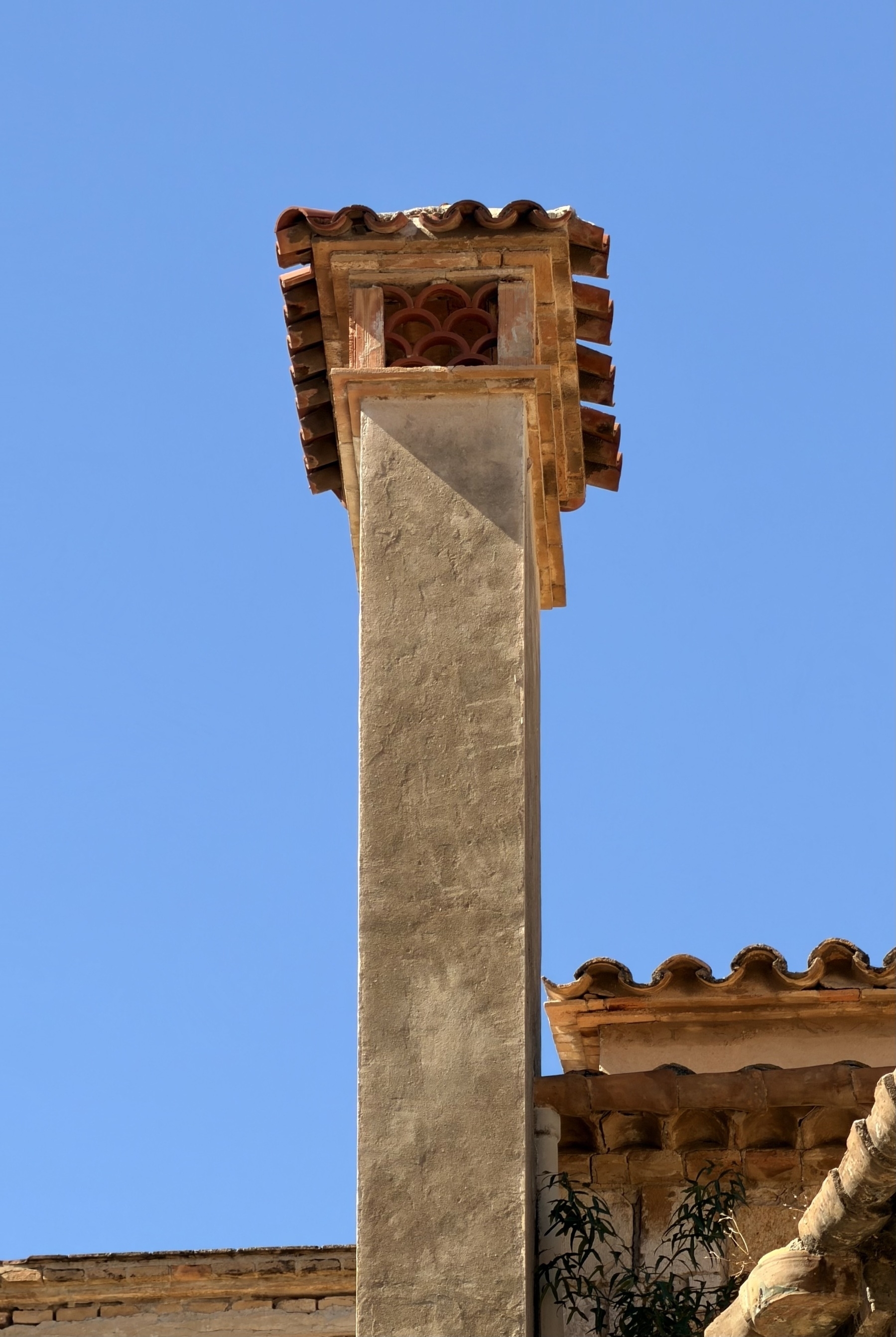A small chimney with a fancy tiled roof.