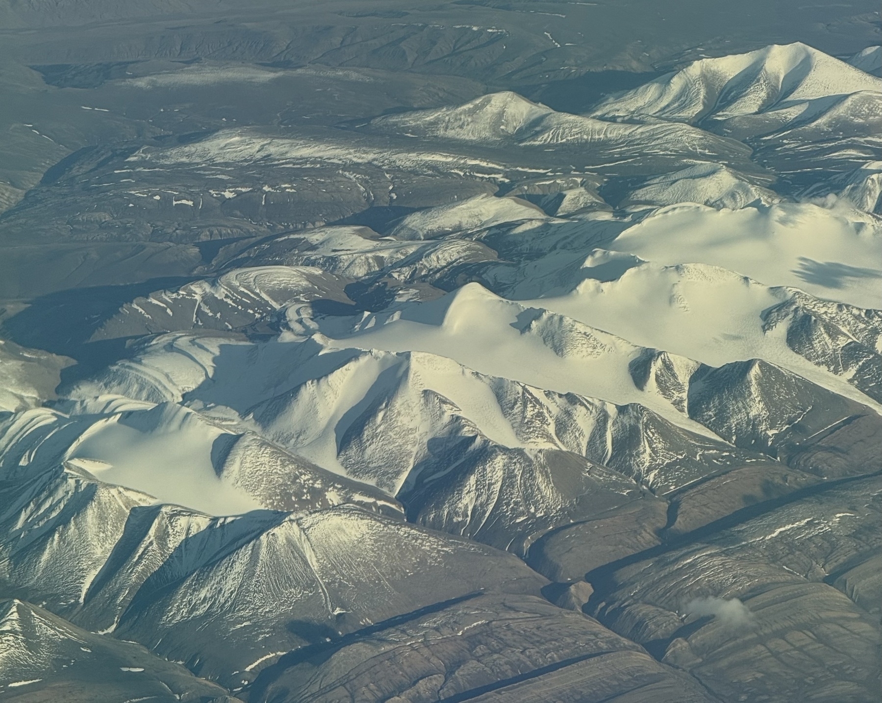Snow capped mountains seen from the air.