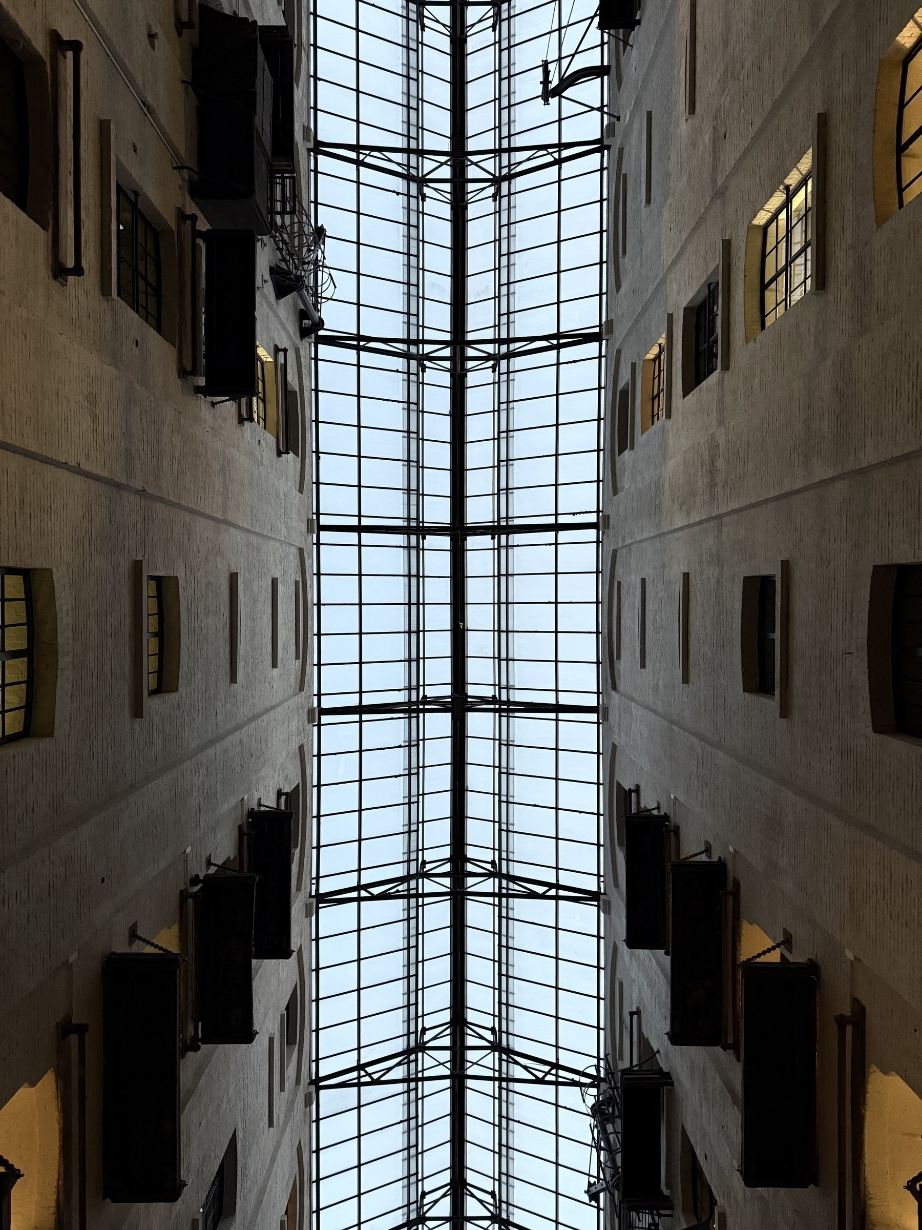 Looking up at a glass roof between two warehouses.