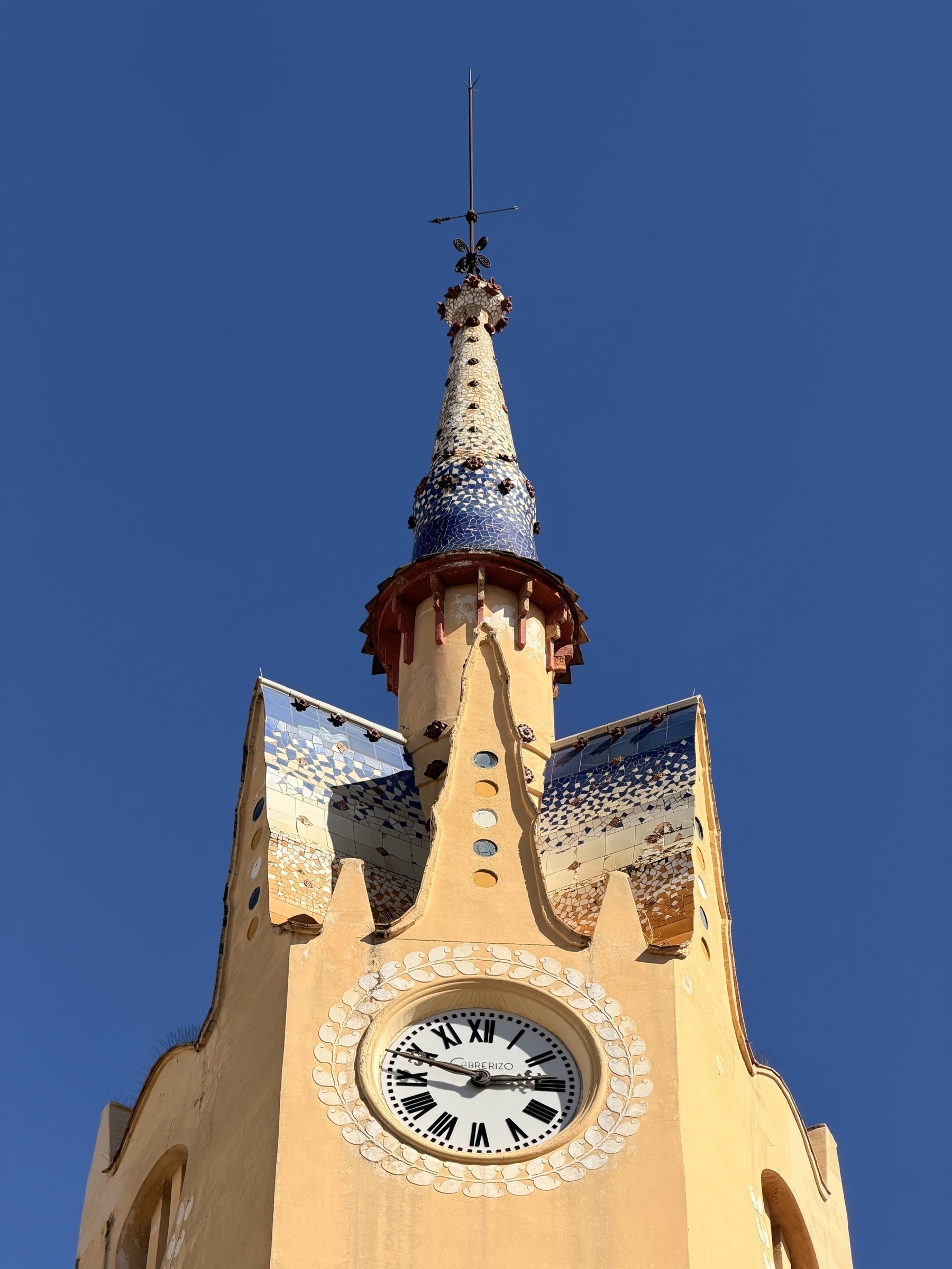 A clock tower with an ornately tiled roof.