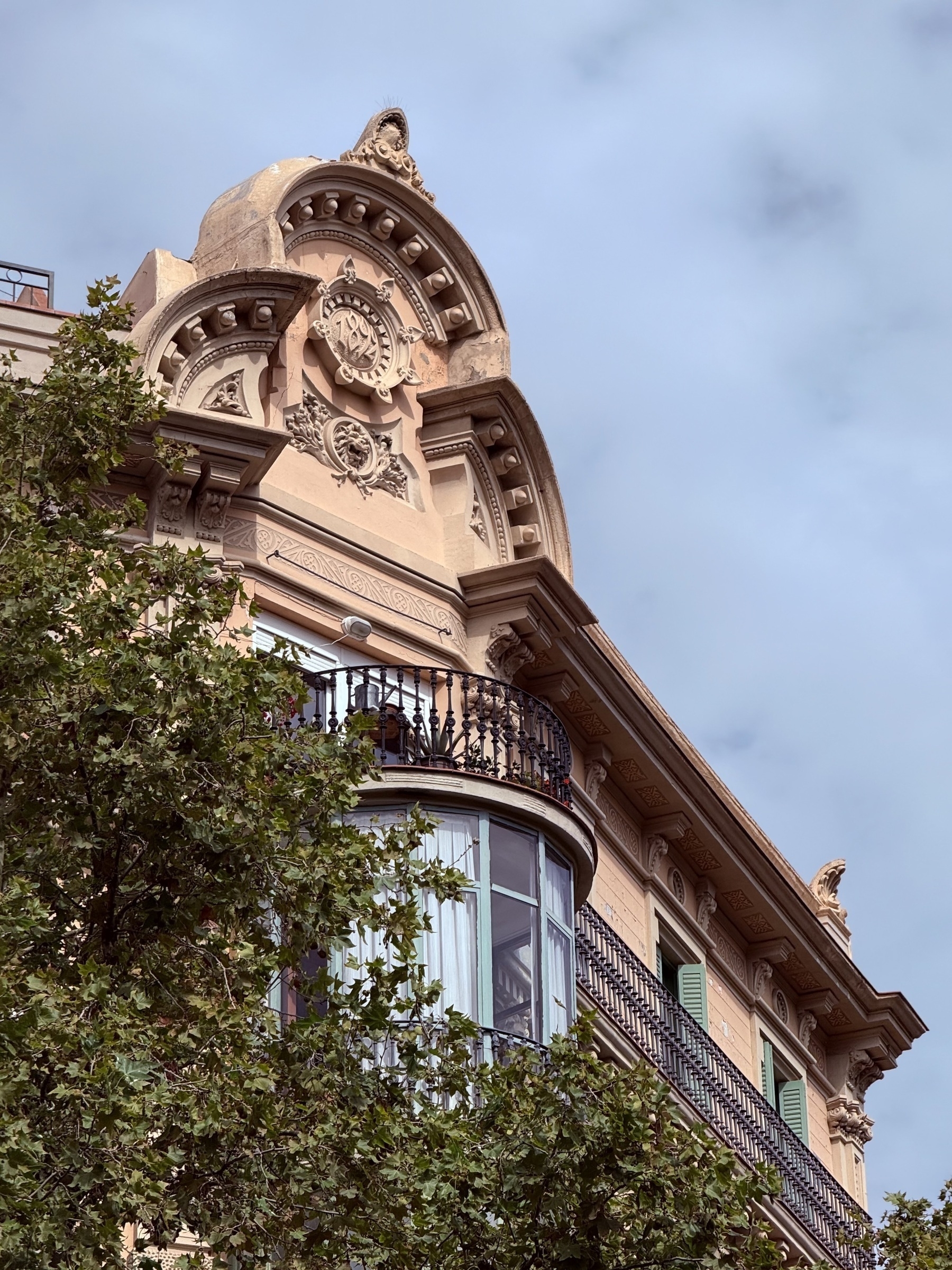 A balcony on top of a bay window at the top of an apartment block in Barcelona.