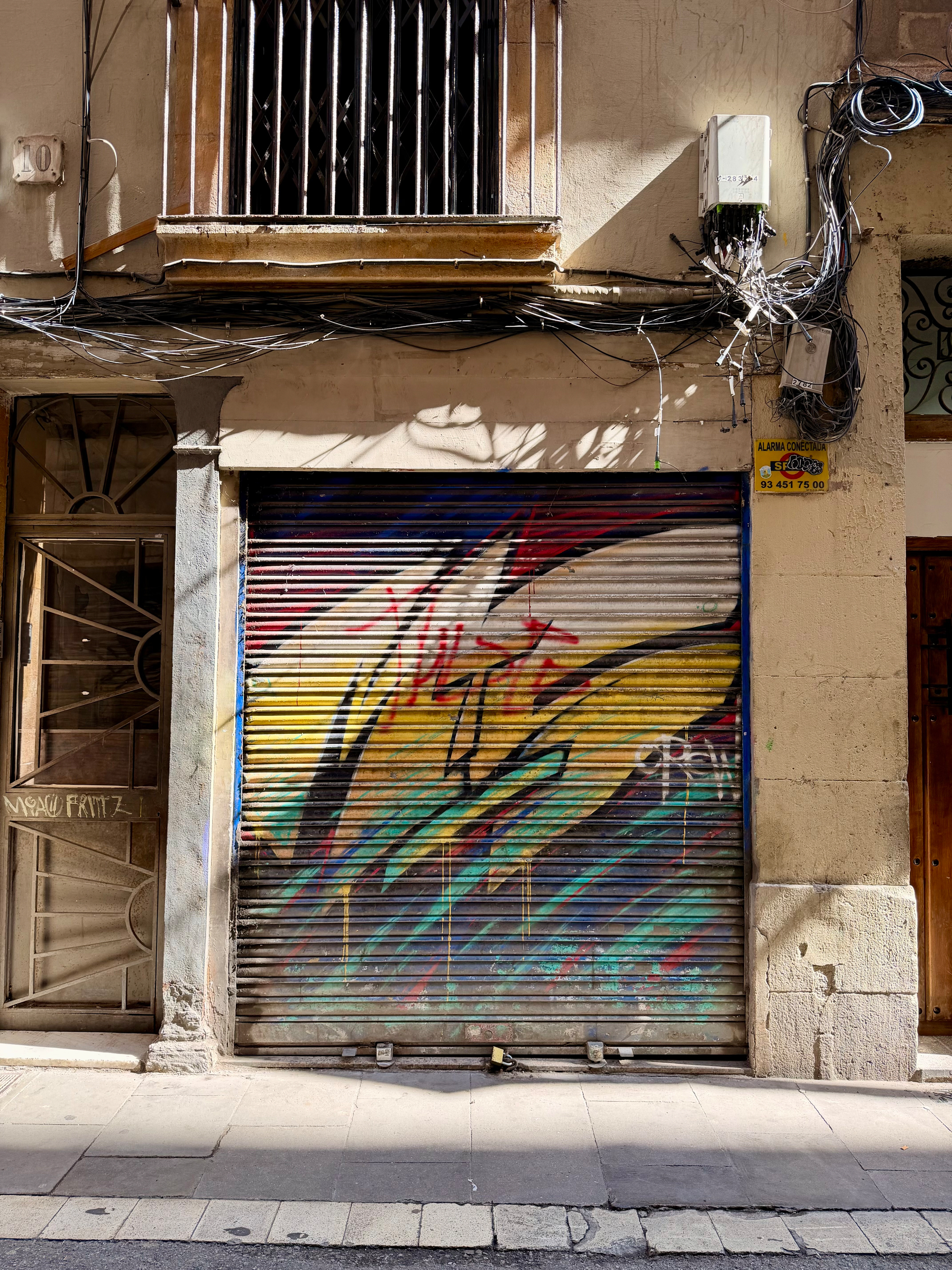 A graffiti covered metal shutter in a wall.