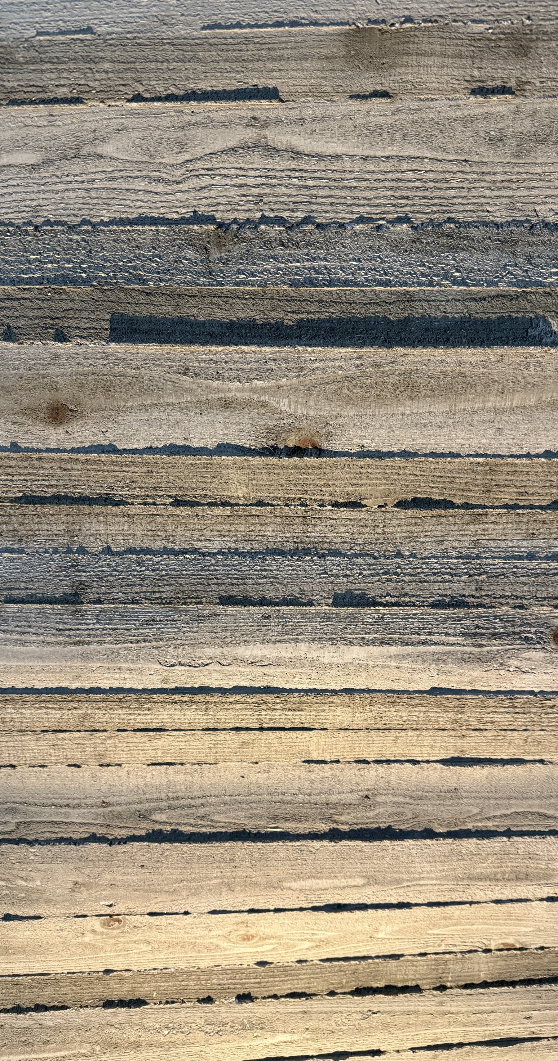Wood shuttered concrete lit from an angle, highlighting its texture.