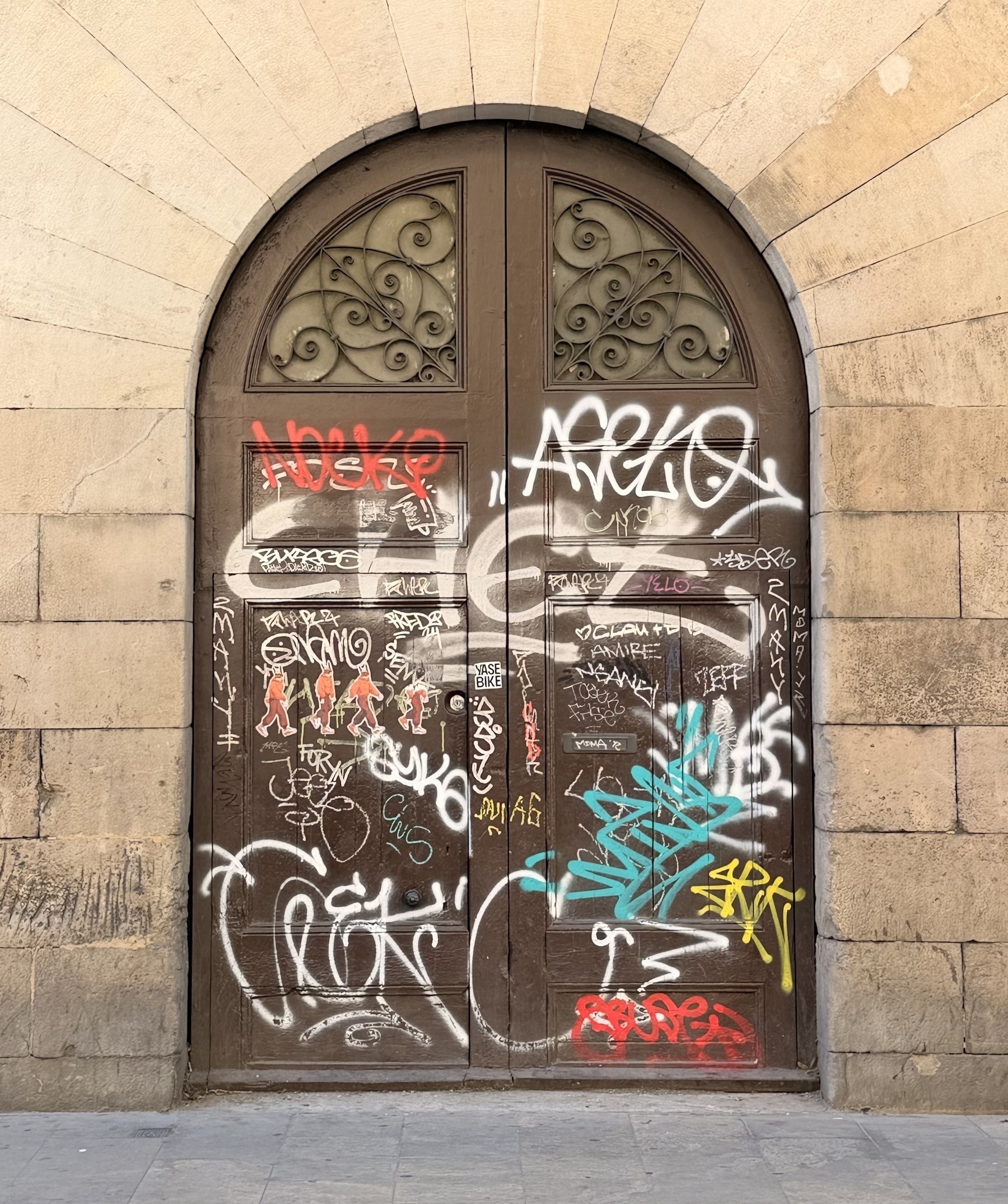 An arched doorway covered in graffiti.