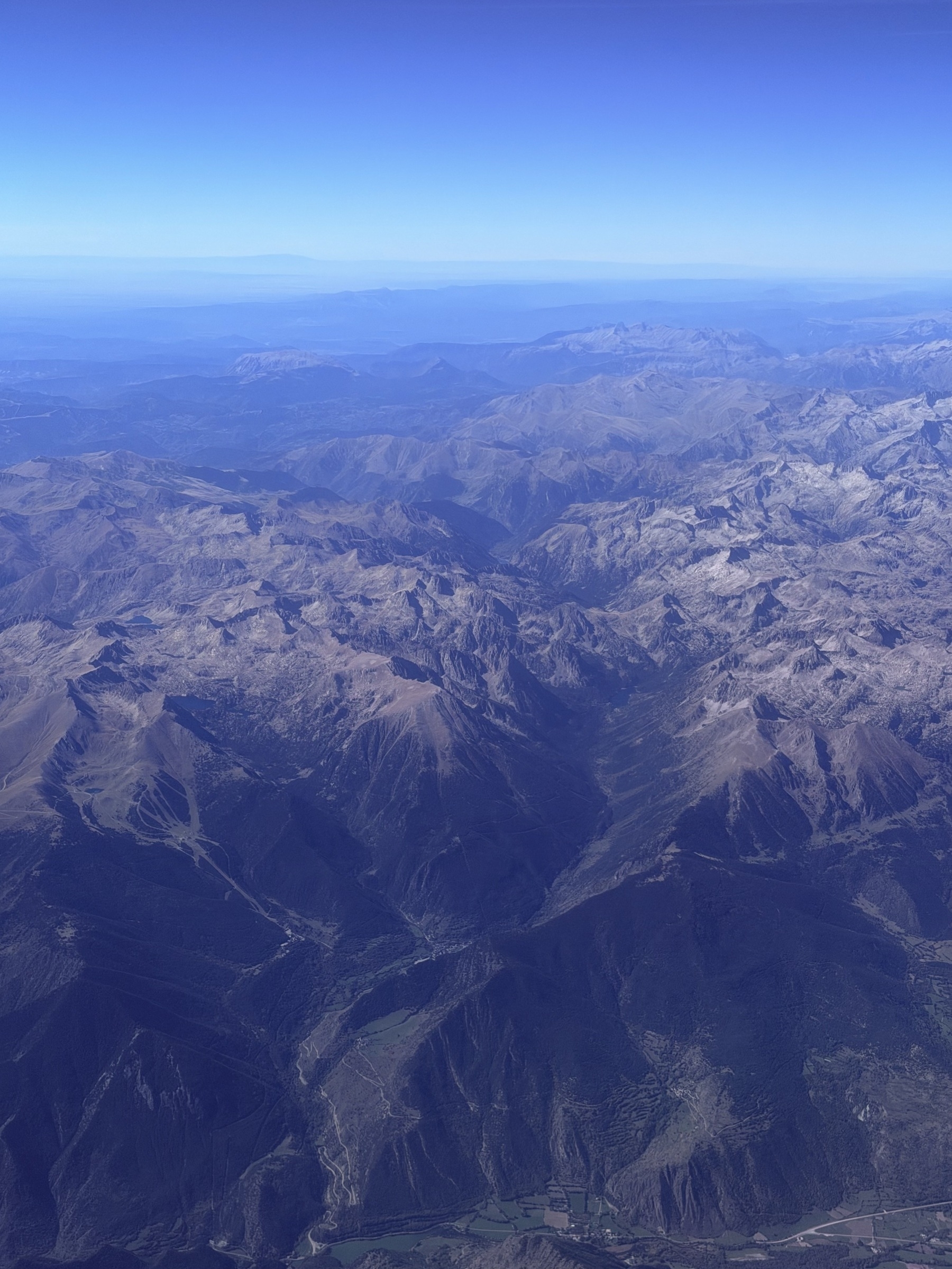 The Pyrenees mountains seen from a plane, stretching off in to the distance.