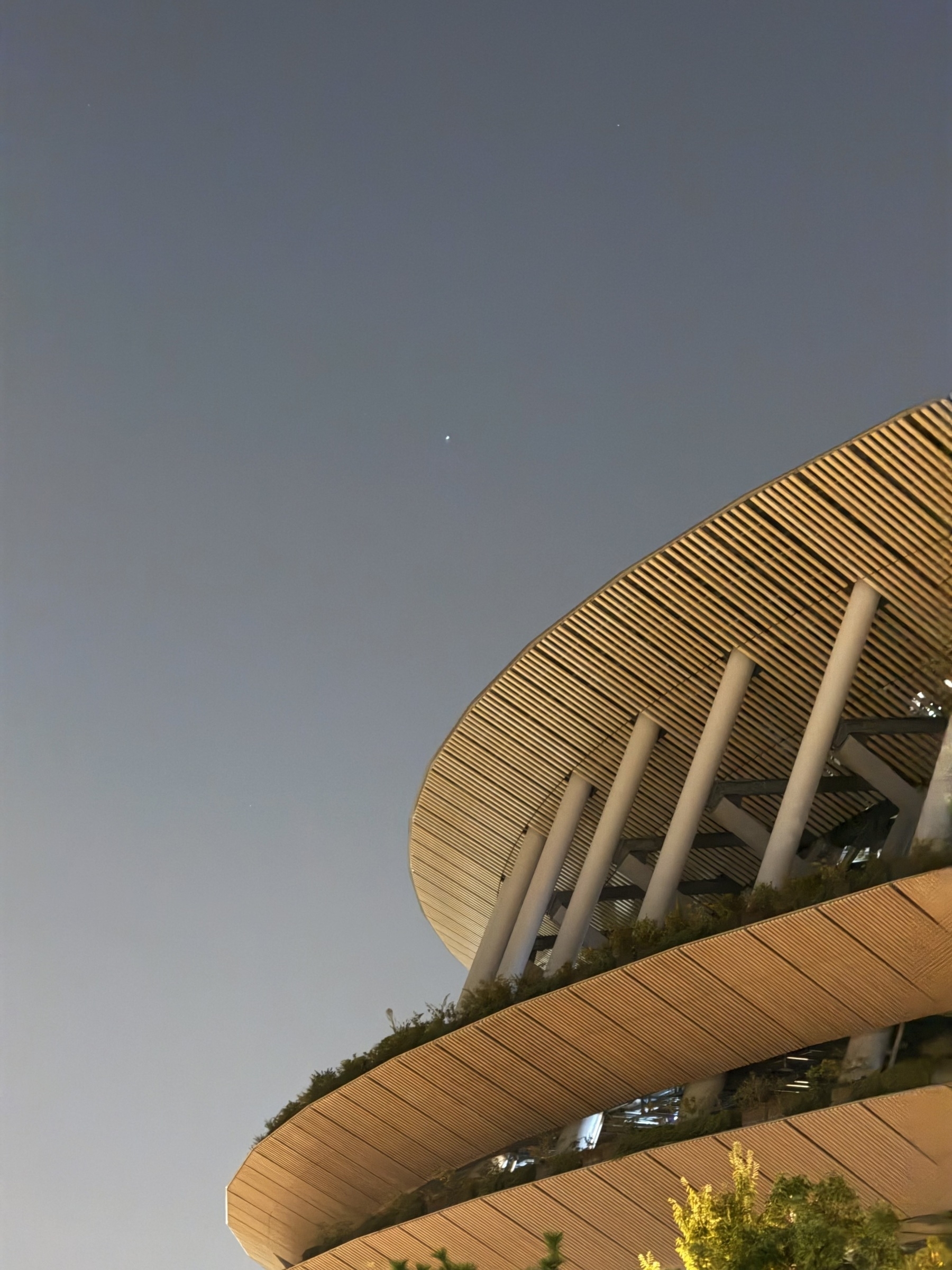 The wood clad outside of the national stadium in Tokyo, with the night sky in the background.