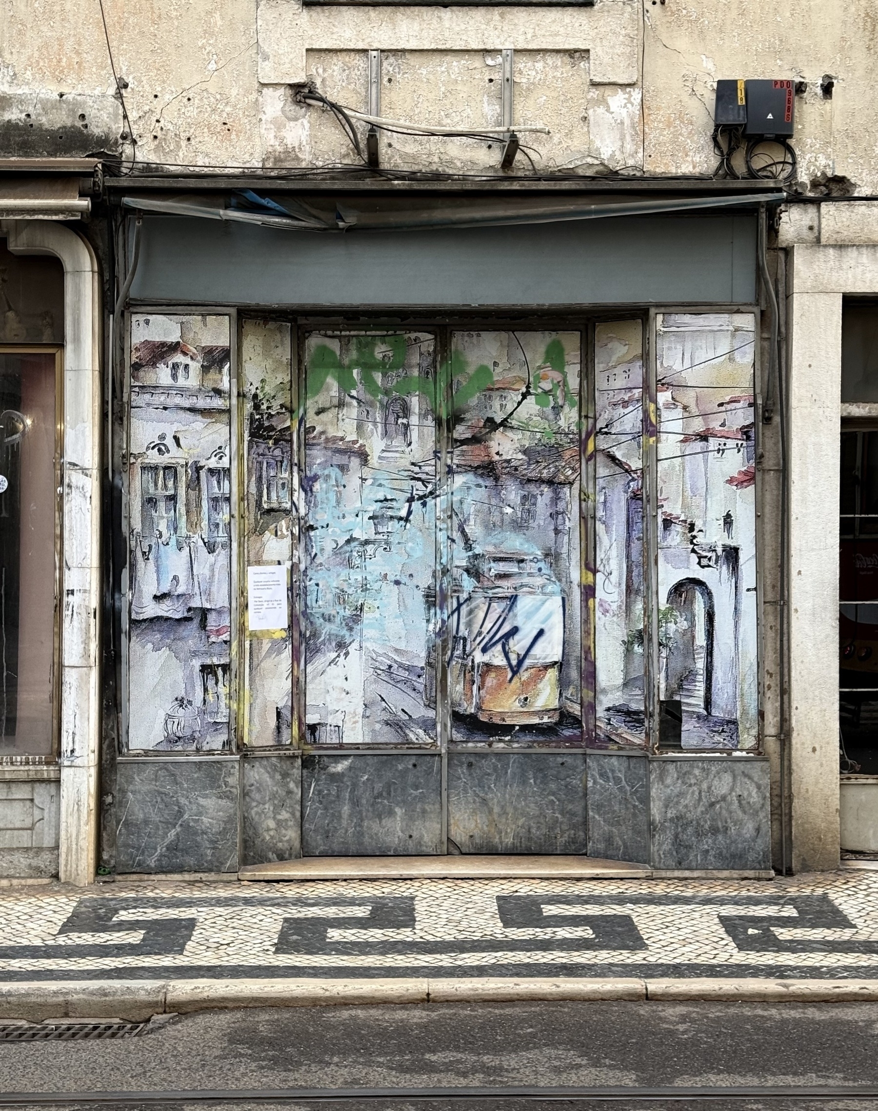 A boarded up shop front with a painting of a tram on it.