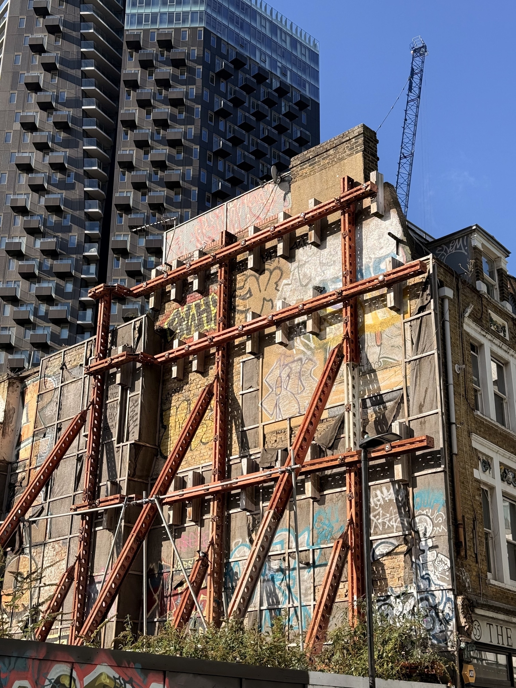 A metal framework holding up the side of a building.