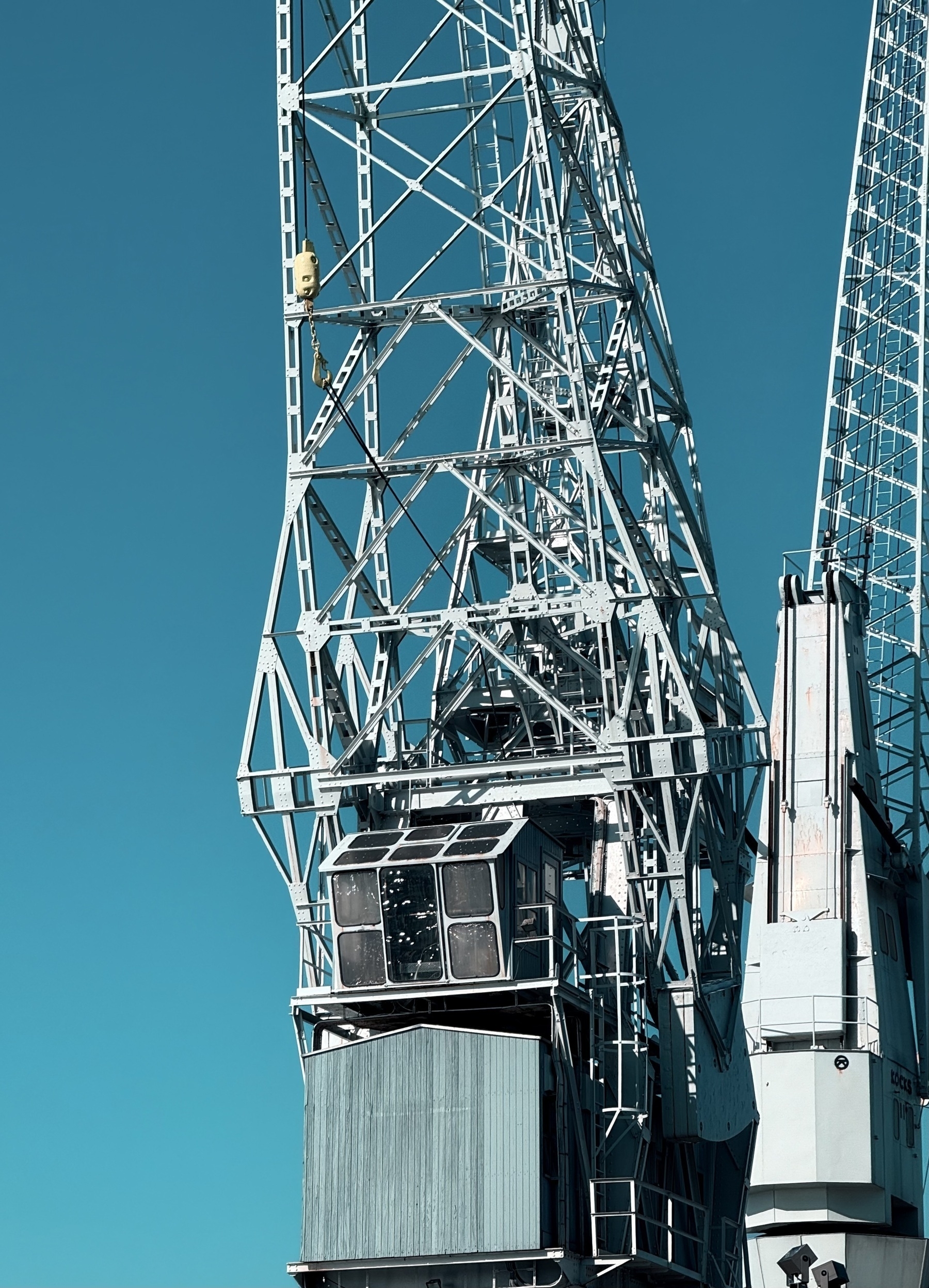 A metal crane against a blue sky.