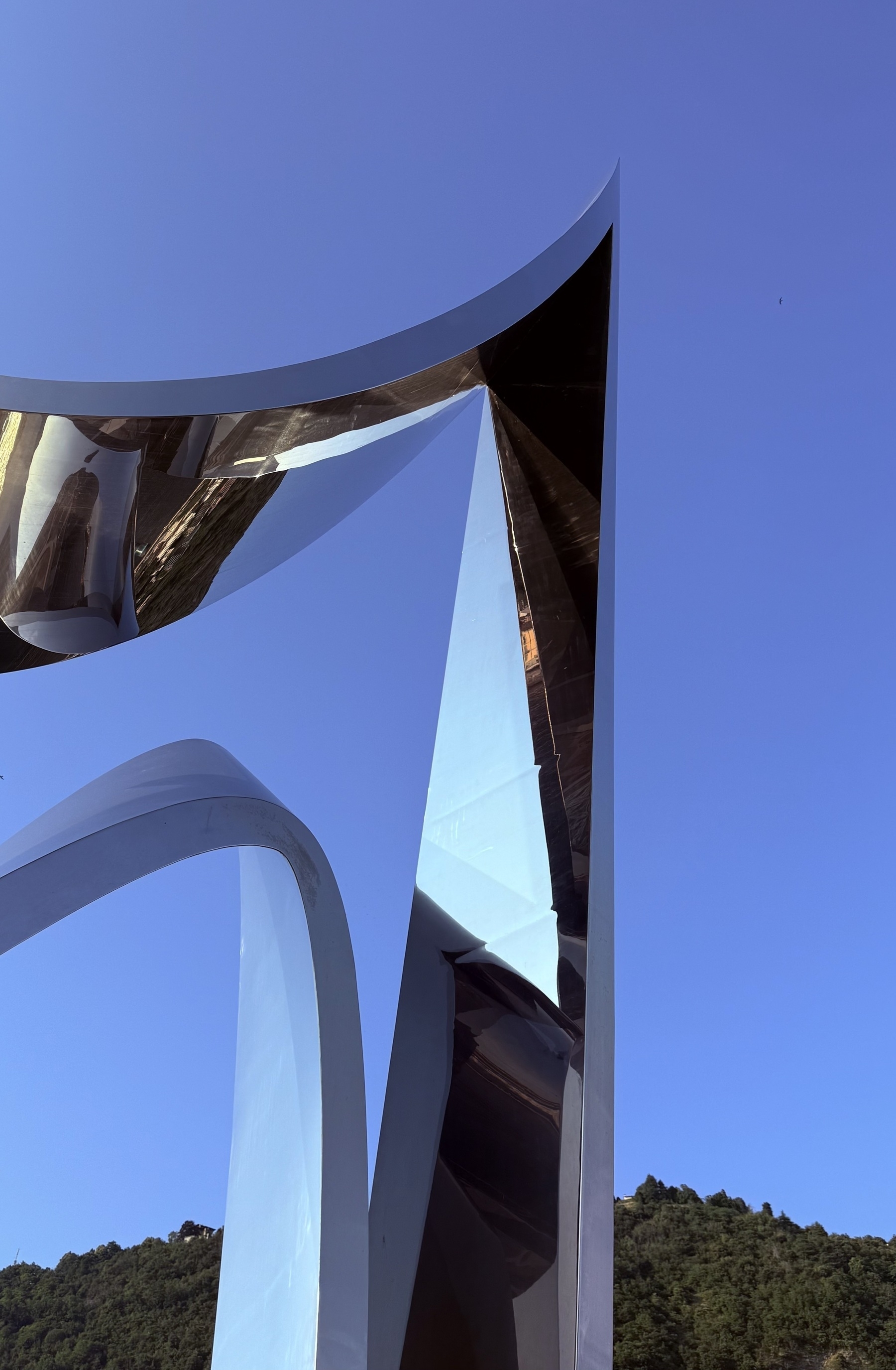 A shiny pointy metal sculpture jutting in to the sky.