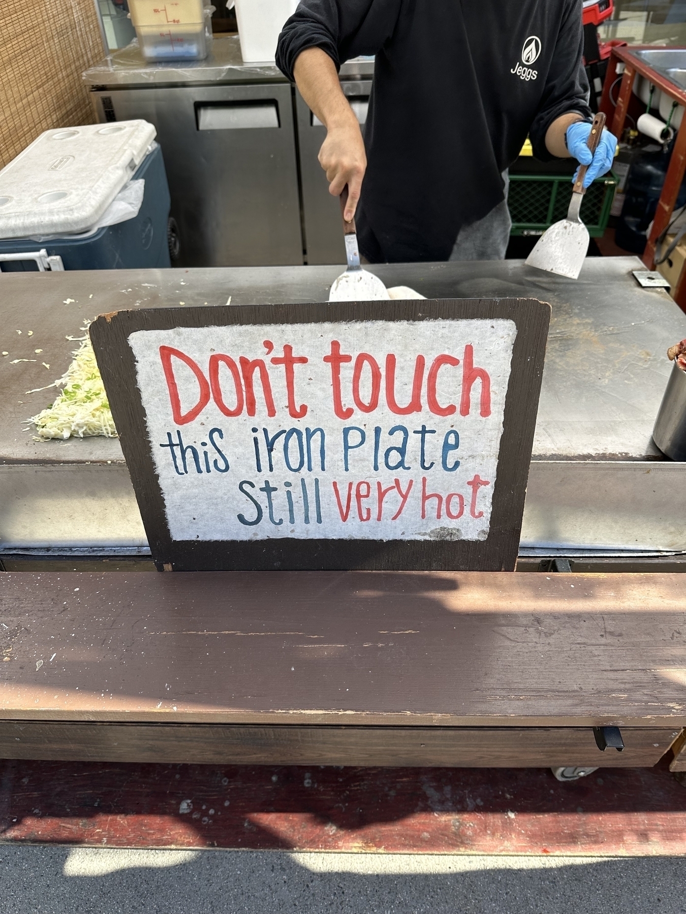 Sign that says “Don’t touch this iron plate still very hot”.