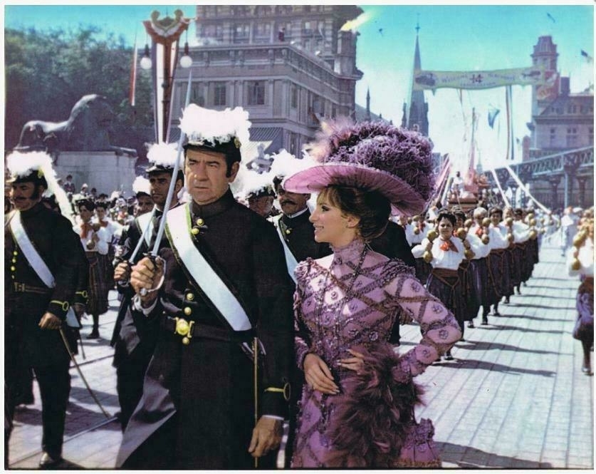 Walter Matthau and Barbra Streisand in Hello, Dolly! They are walking together in the parade.