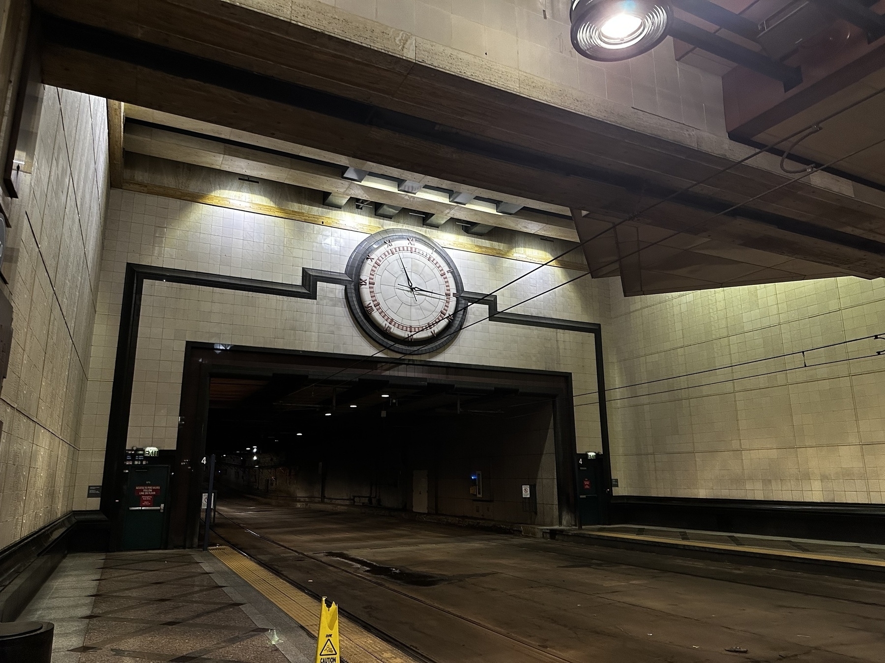 Giant analog clock over a double-wide light rail tunnel