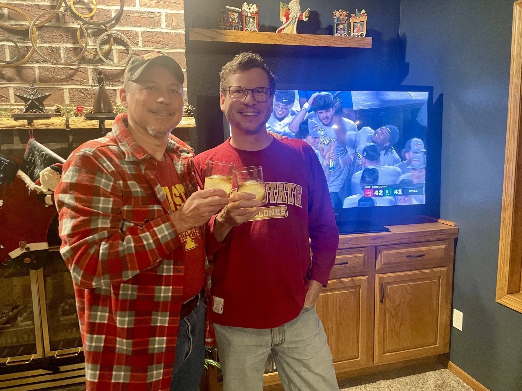 My brother and I wearing Iowa State shirts and lifting rocks glasses of bourbon. Iowa State victory celebration on the TV behind us. Iowa State 42, Miami (FL) 41. 