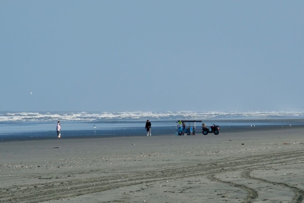 A group of people standing at the edge of the sea. 