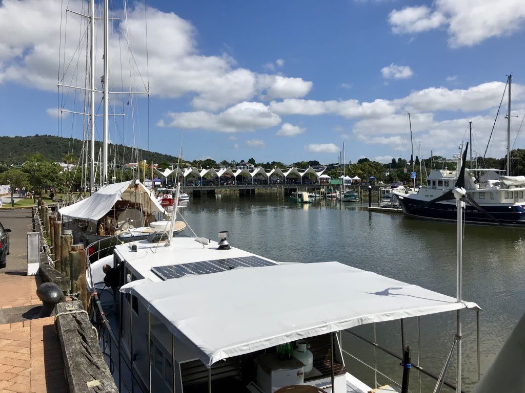 A view across a marina to market stalls. 