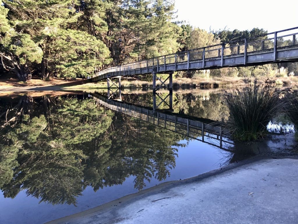 River like glass by the footbridge. 