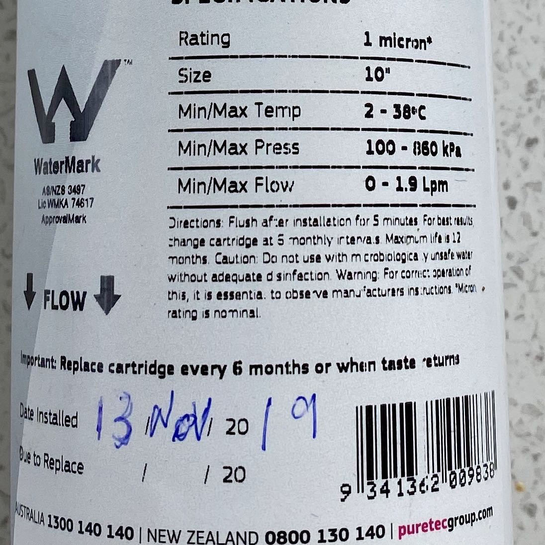 Close up of filter label showing direction of flow. 