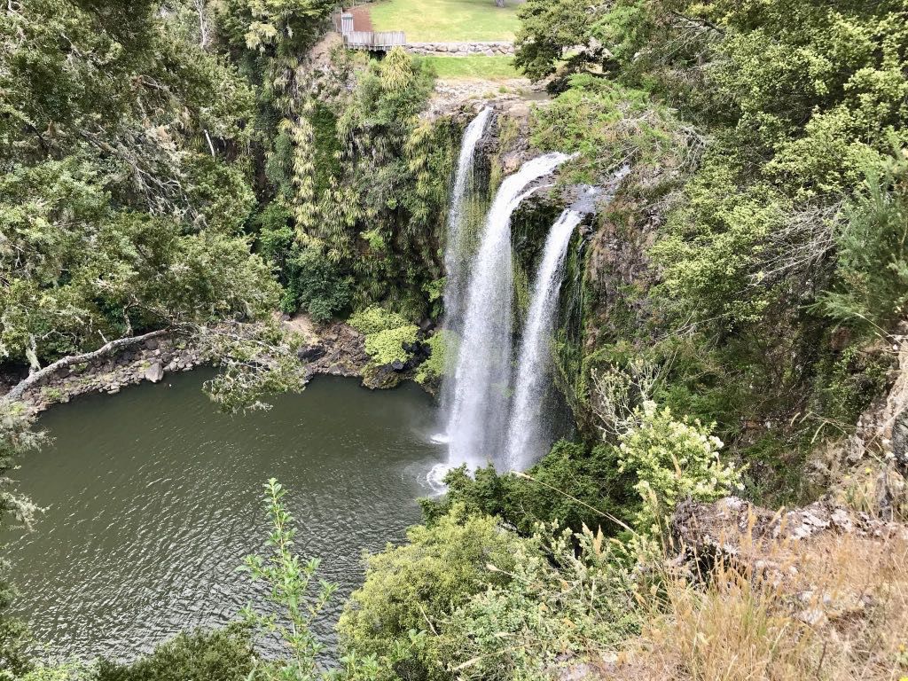 Waterfall streams falling into a pool as seen from above and to one side. 