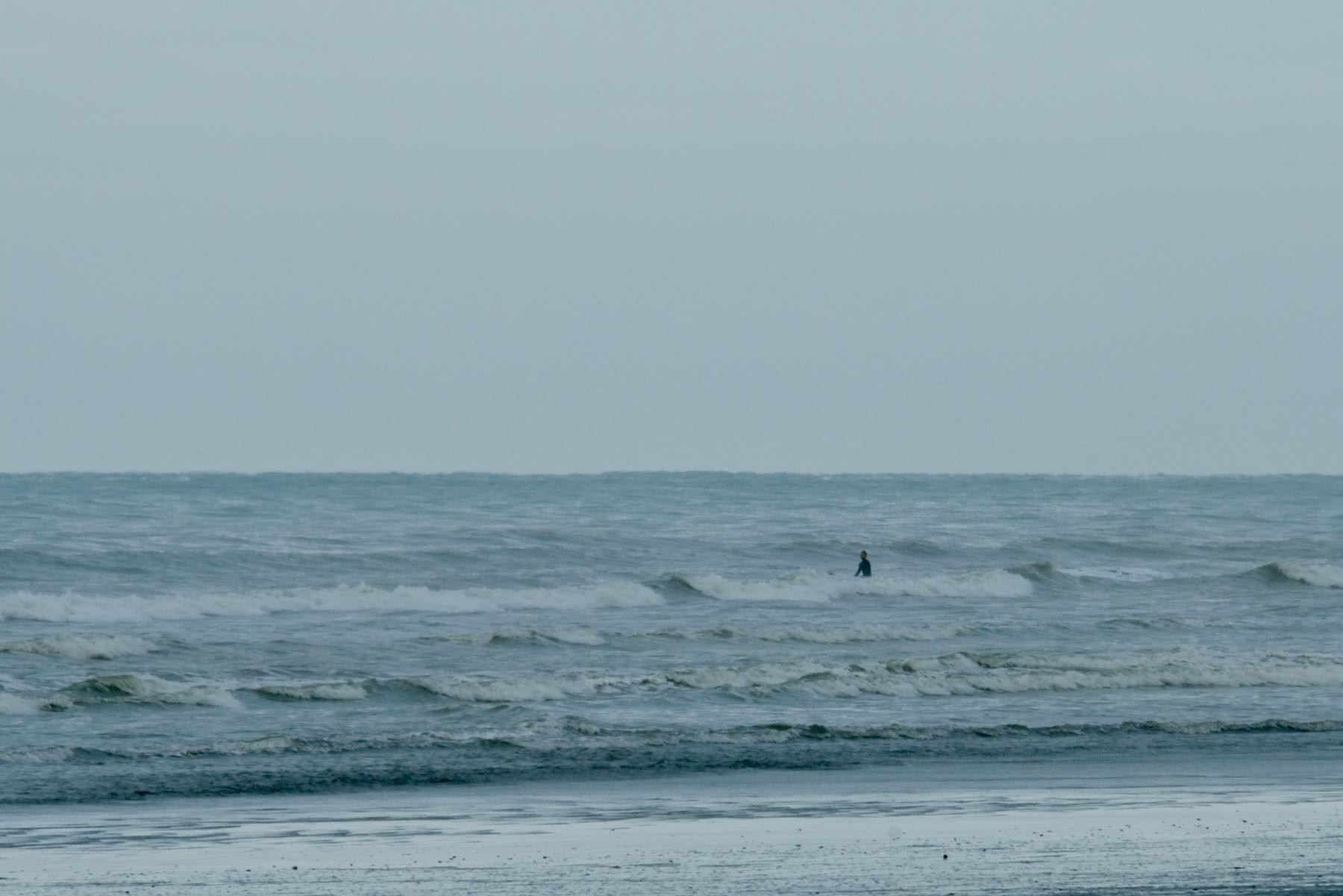 A person sitting on a surboard in the sea. 