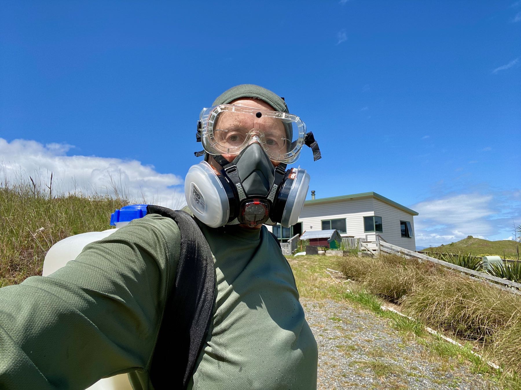 Miraz with backpack sprayer and breathing mask, eye mask and cap. 